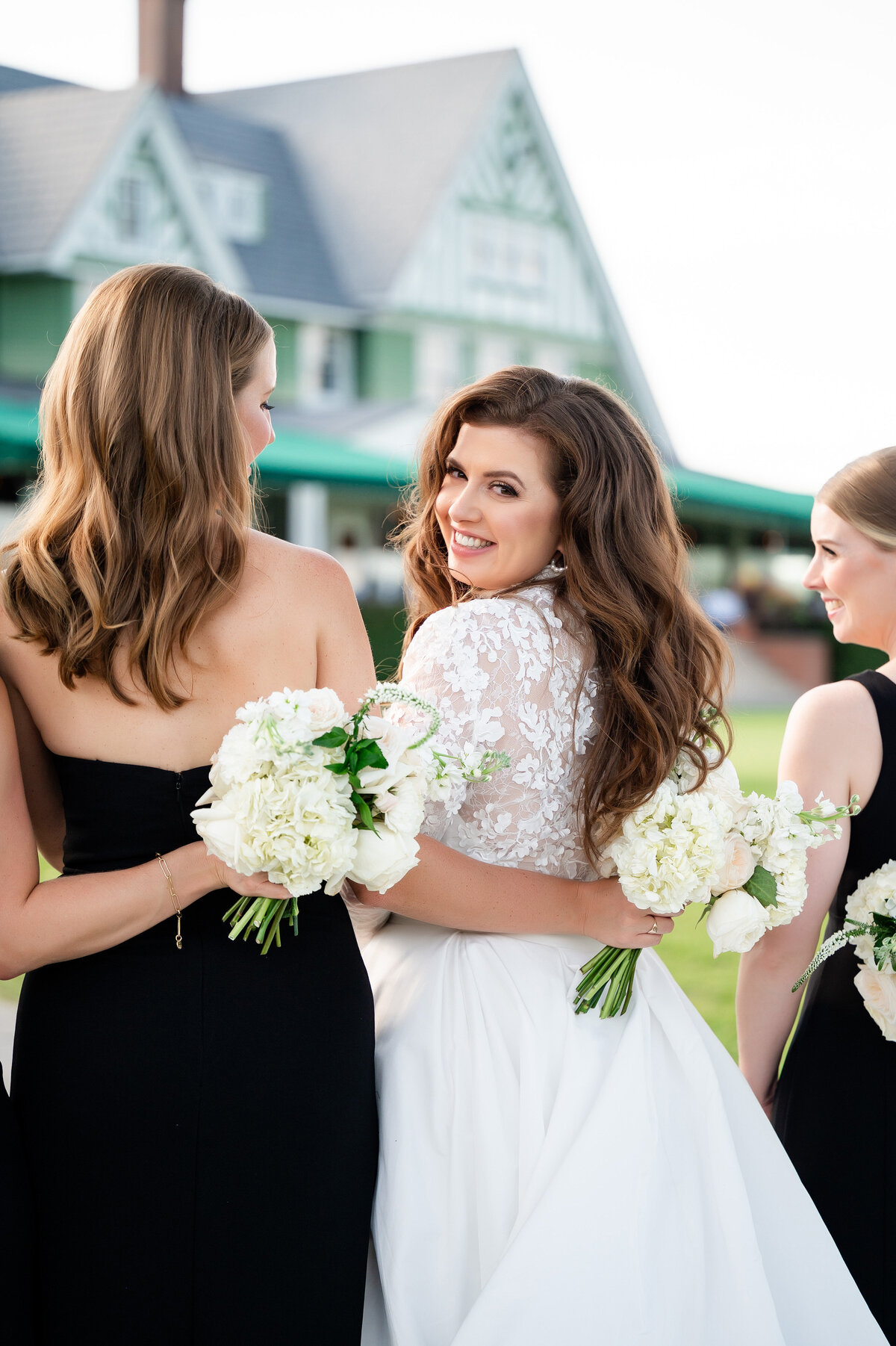 bride posing with bridesmaids on golf course of oakmont country club