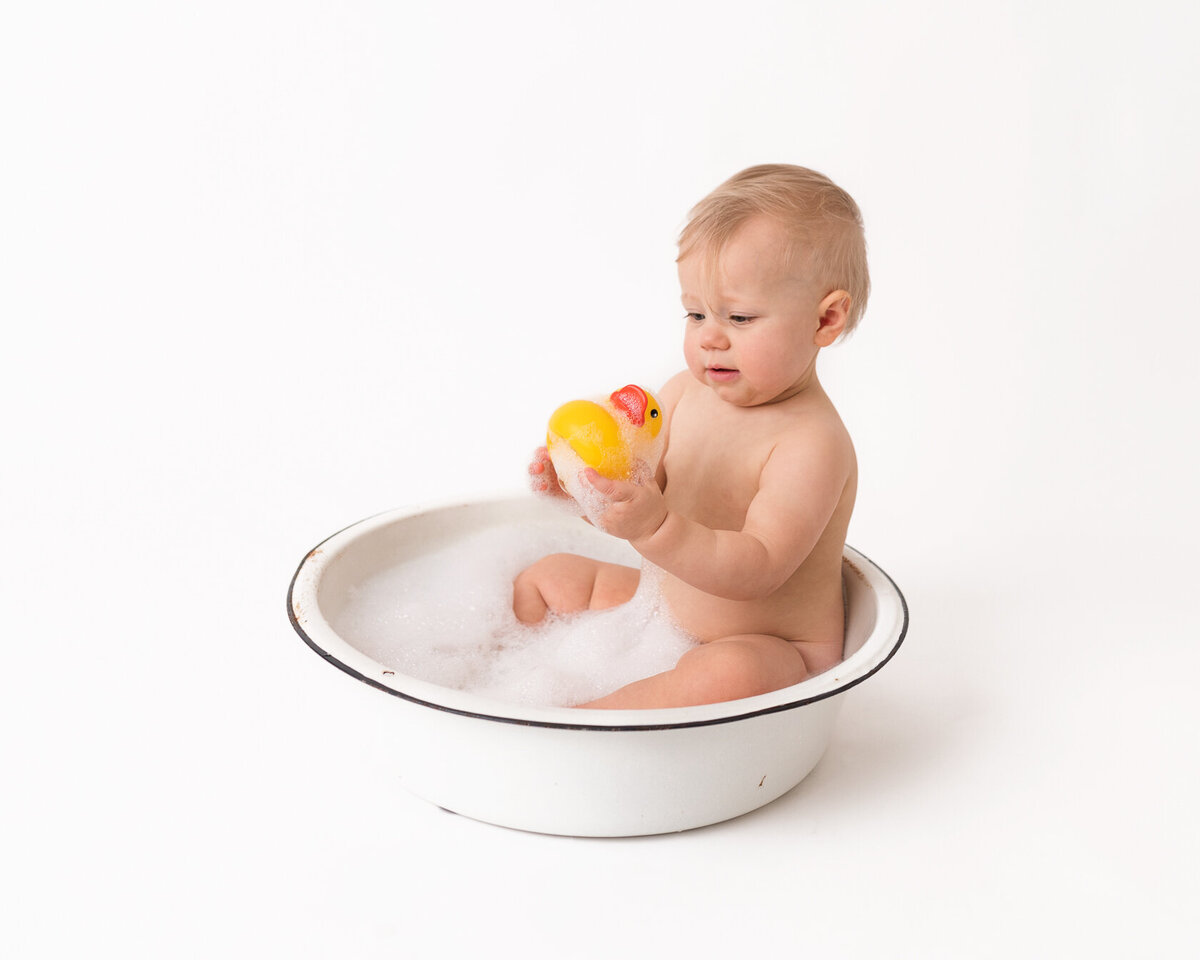 Cute baby in a tub cake smash portrait session in Houston