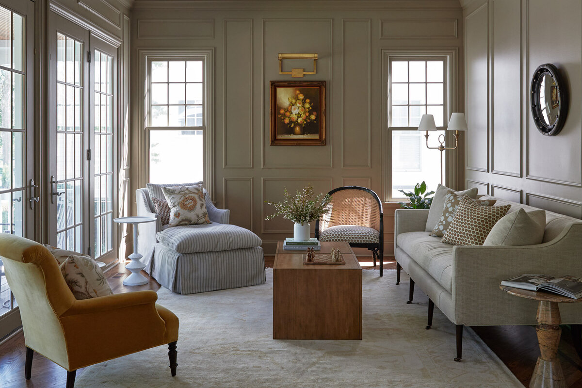 Living room at the Pillement House project with green walls and neutral seating