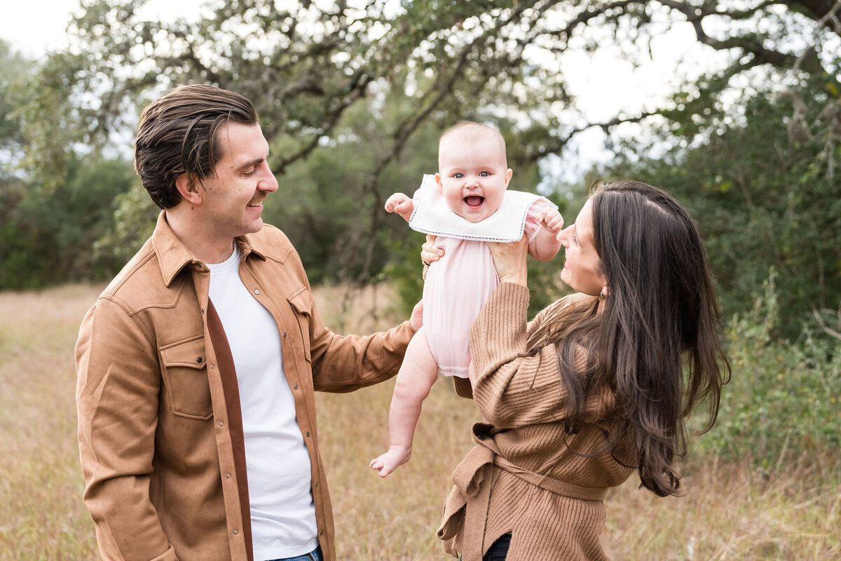 Family plays during a family photoshoot at Circle C Park in Austin, Texas.