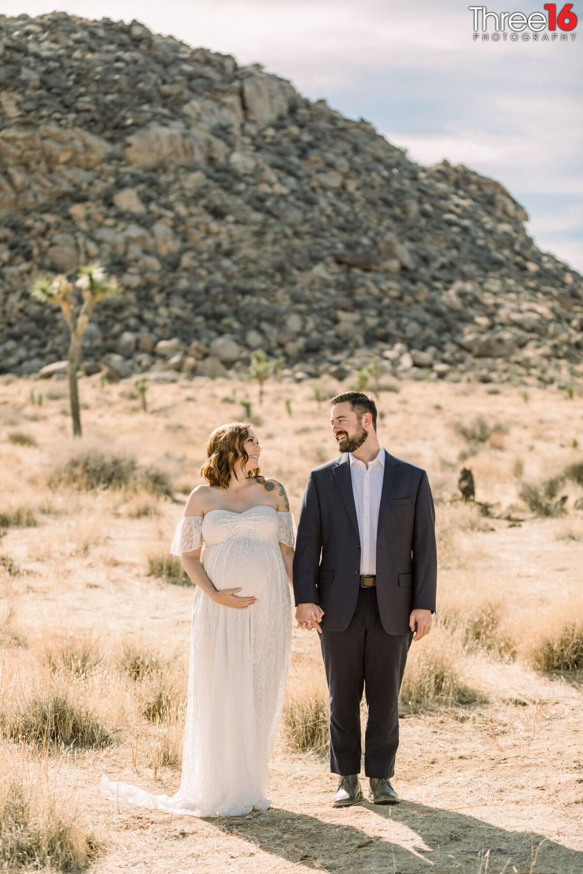 Husband and Wife hold hands during their maternity photo session