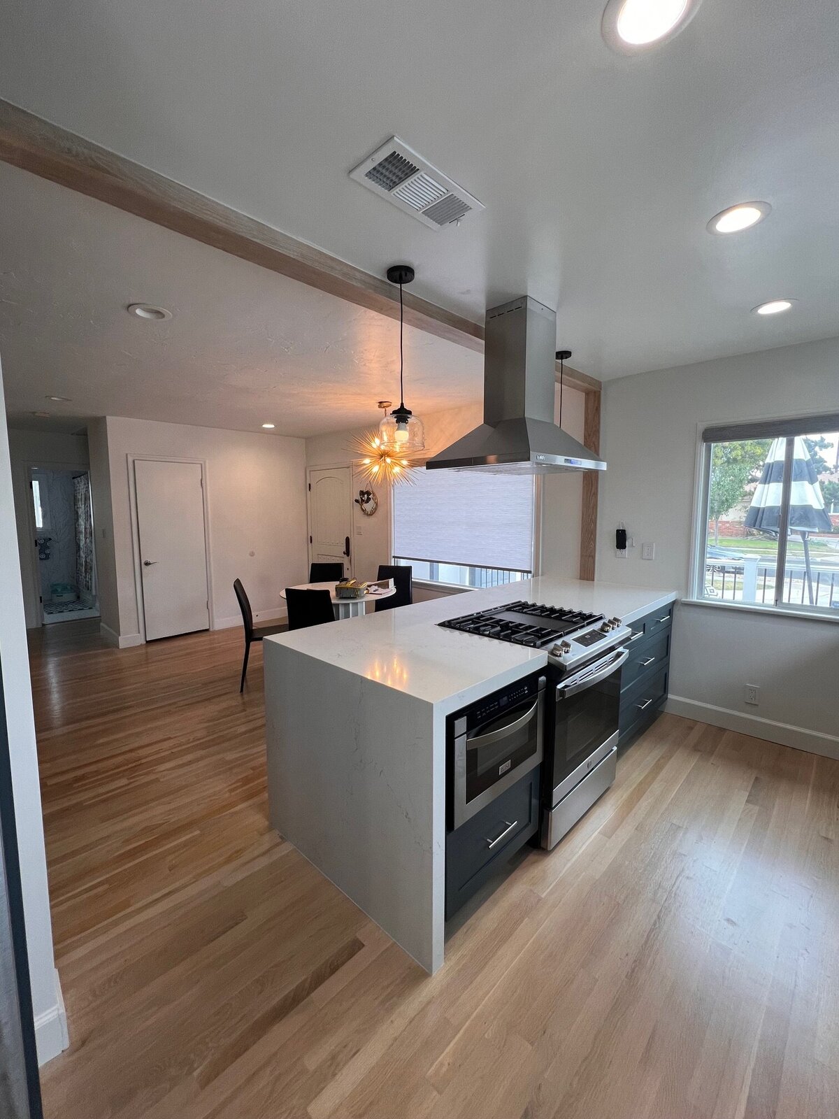 open-concept-kitchen-black-cabinets-wood-flooring