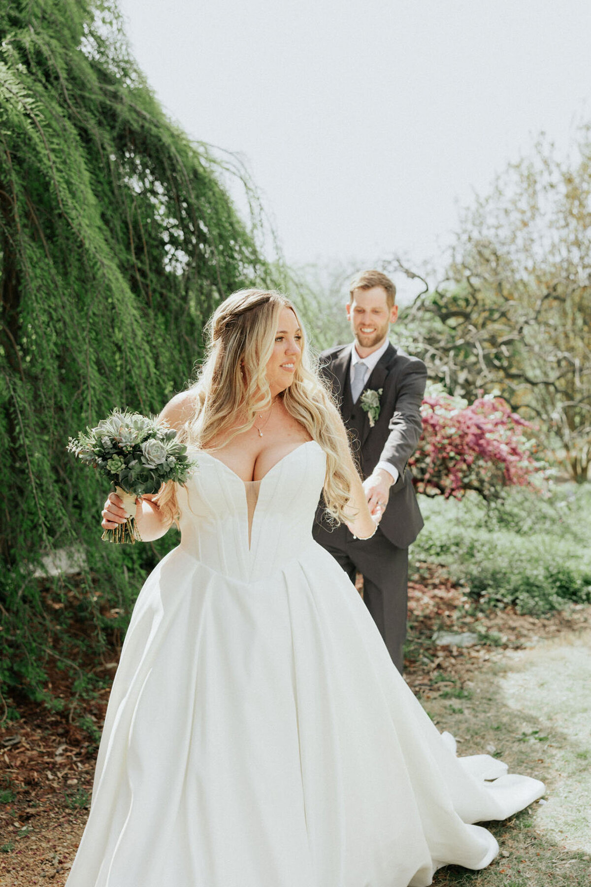 Groom reaching for bride during first look