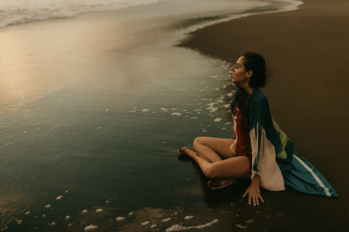 Creative headshot of woman peacefully meditating on San Francisco beach