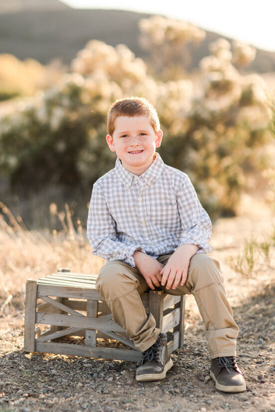 portrait-of-young-boy-sitting-on-crate