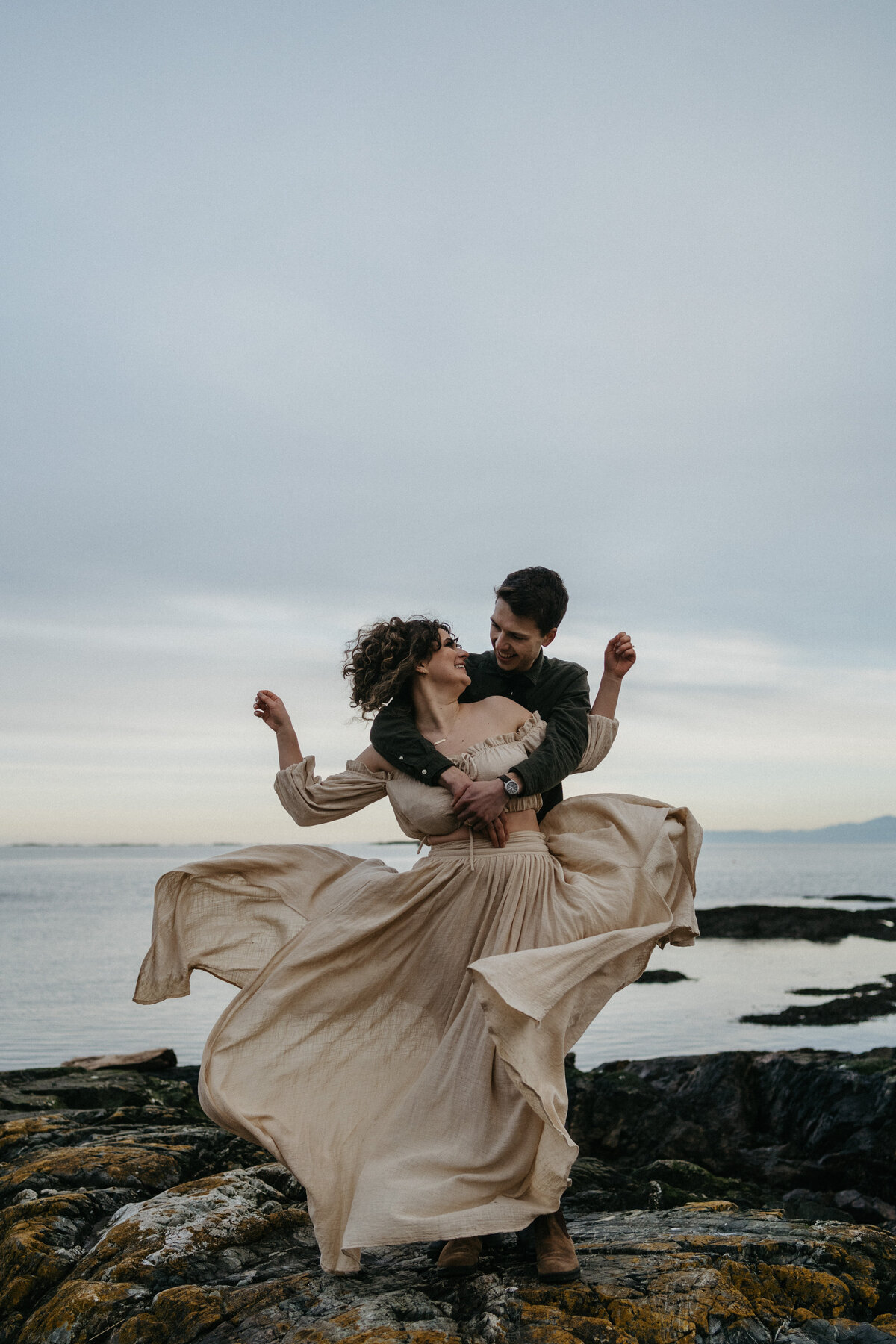 Couple embracing on windy shoreline