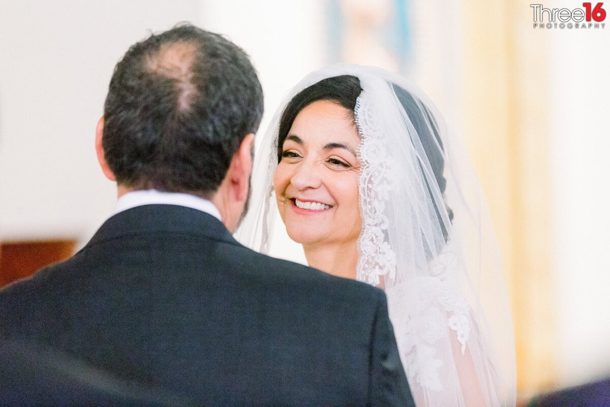 Bride shines a big smile at her Groom during the wedding ceremony