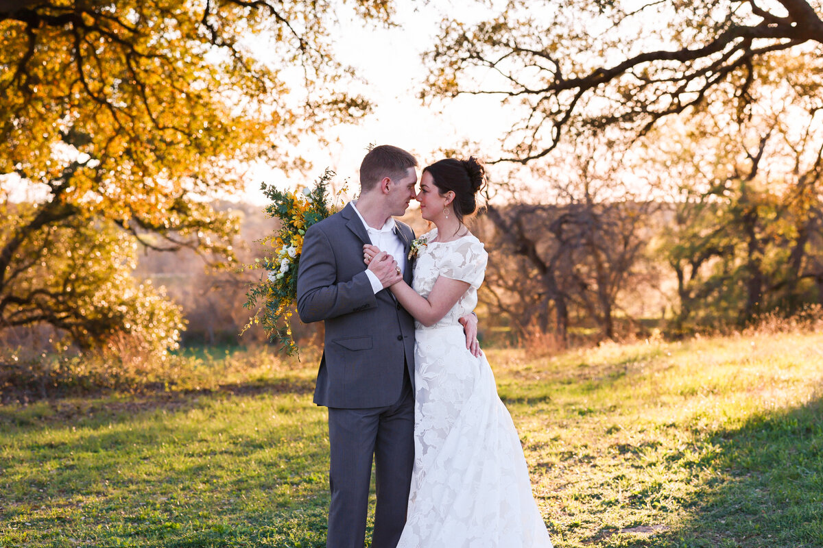 bride and groom. kissing with yellow trees in rear by Austin Texas wedding photographer Amanda Richardson Photography