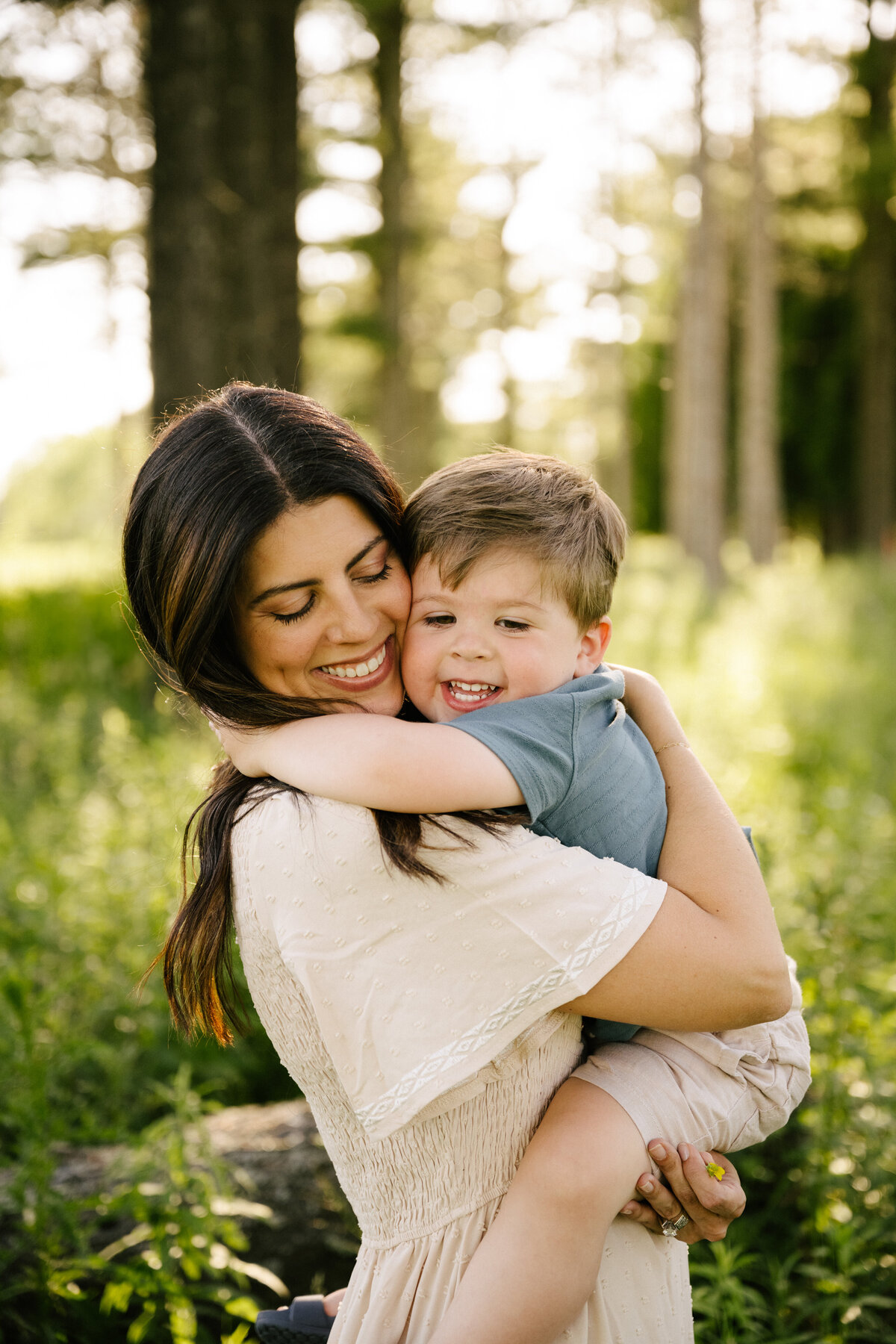 mom hugging little boy smiling