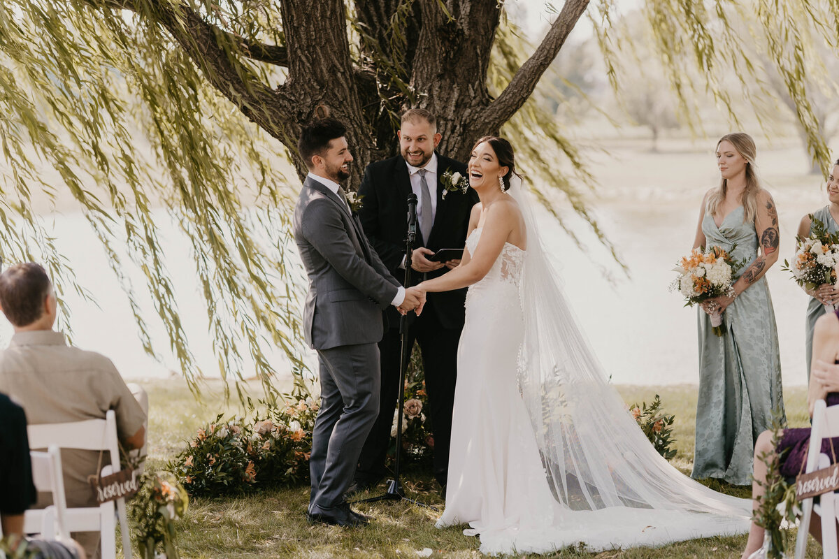 Bride and groom laughing during their ceremony.