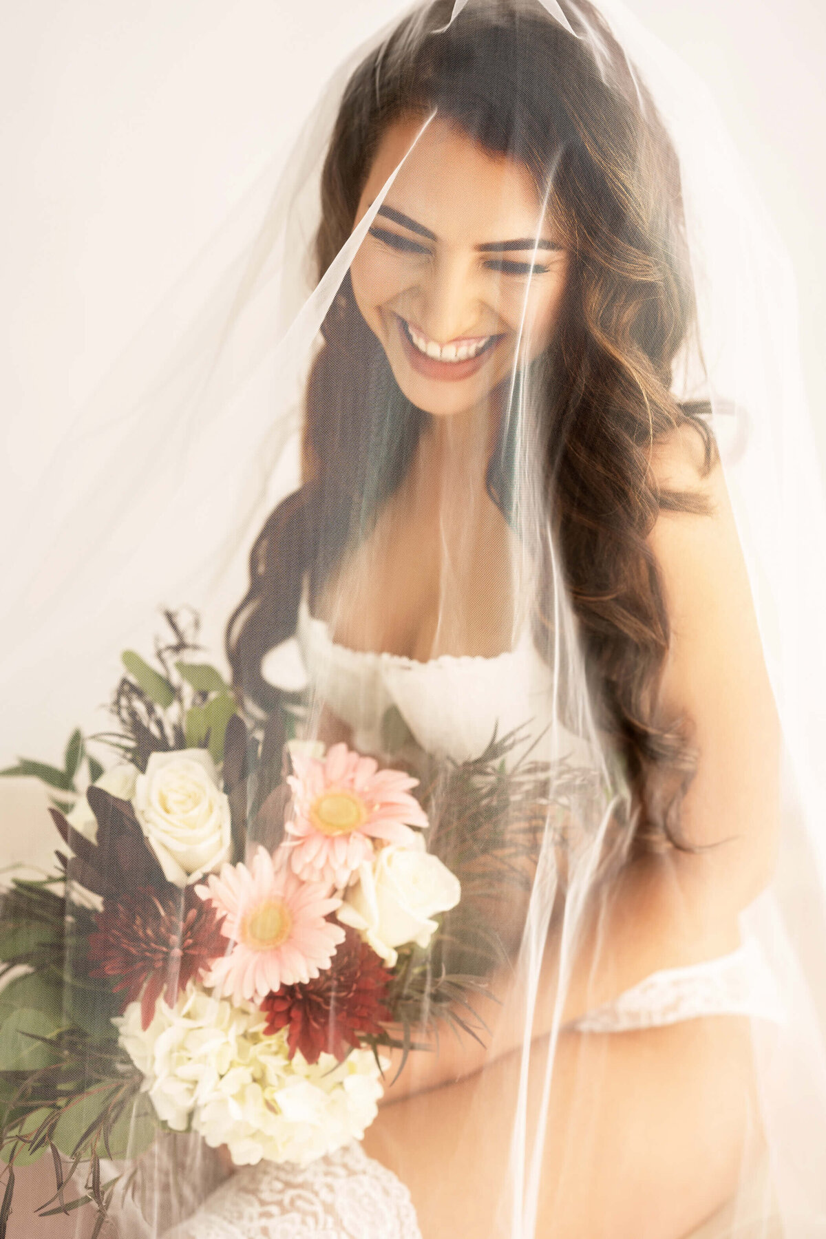 Romantic bridal boudoir session with soft veiled elegance.