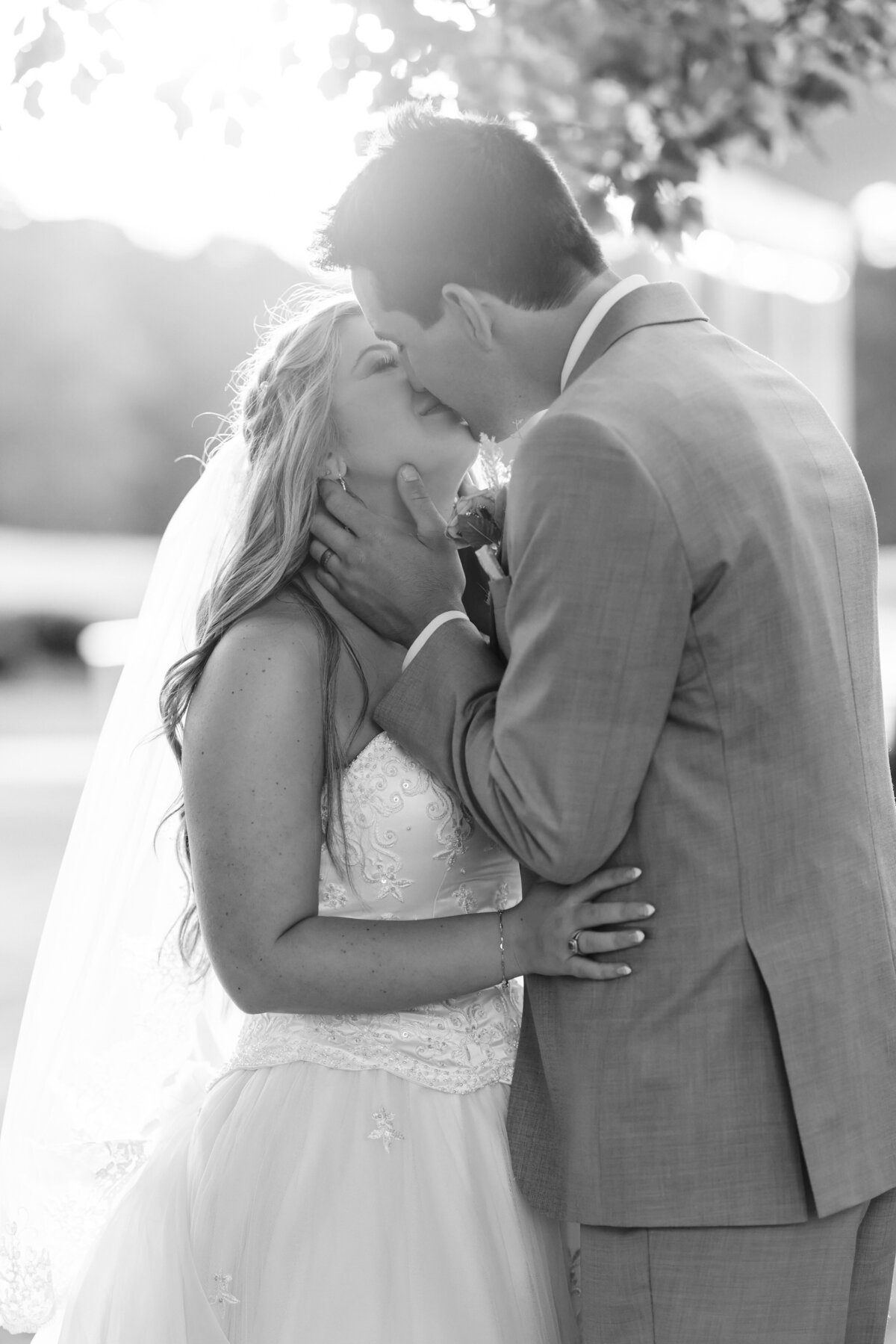 Bride & Groom kiss in field at Milford Farm