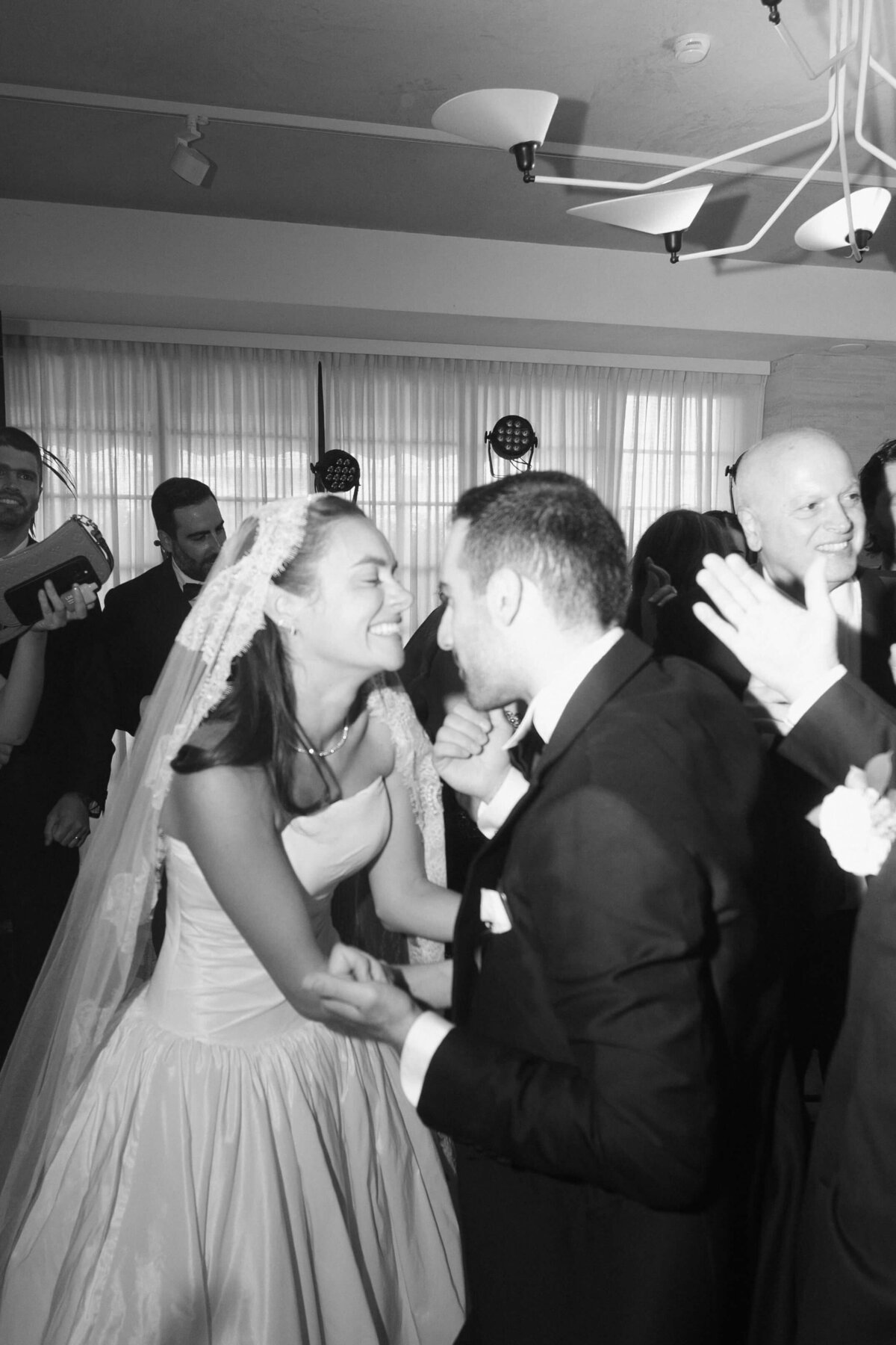 Groom and bride greeting guests in energetic party scene

