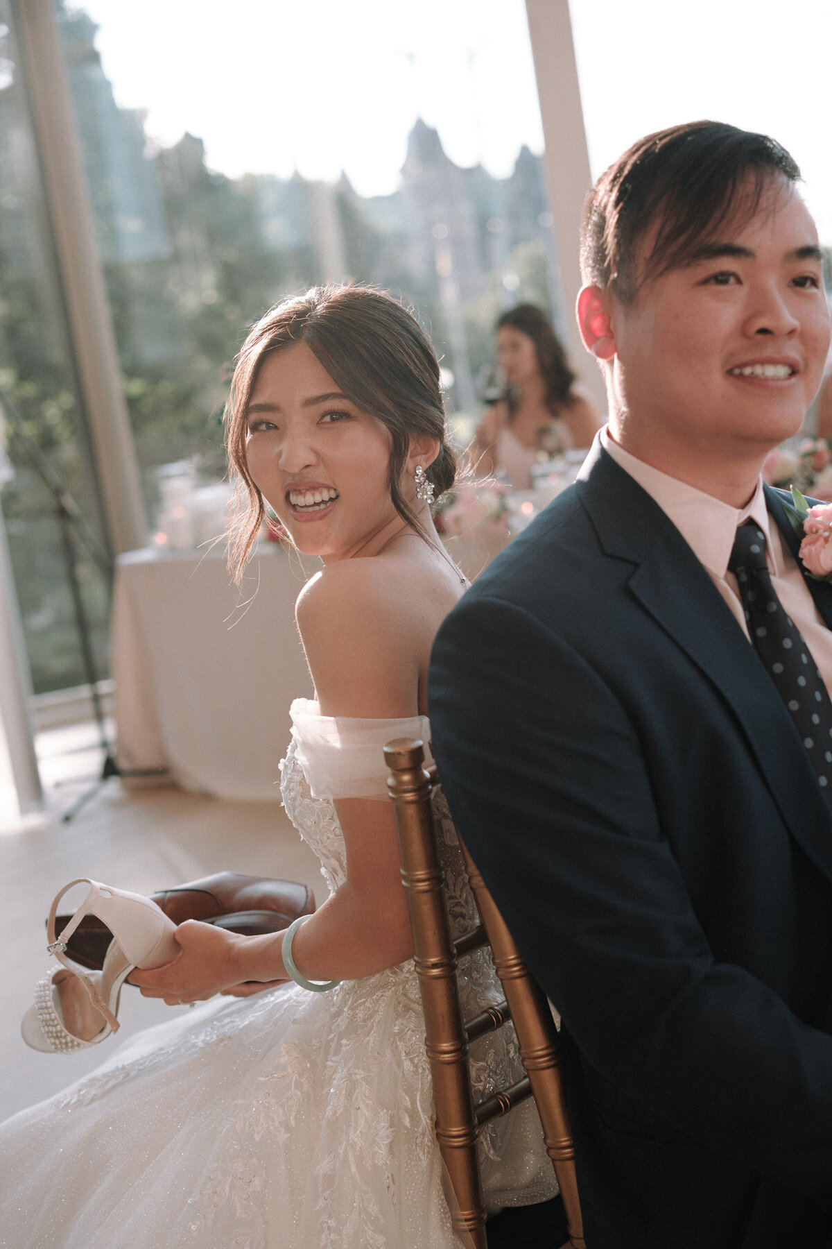 The lovebirds playing games  with shoes having a great time during their reception