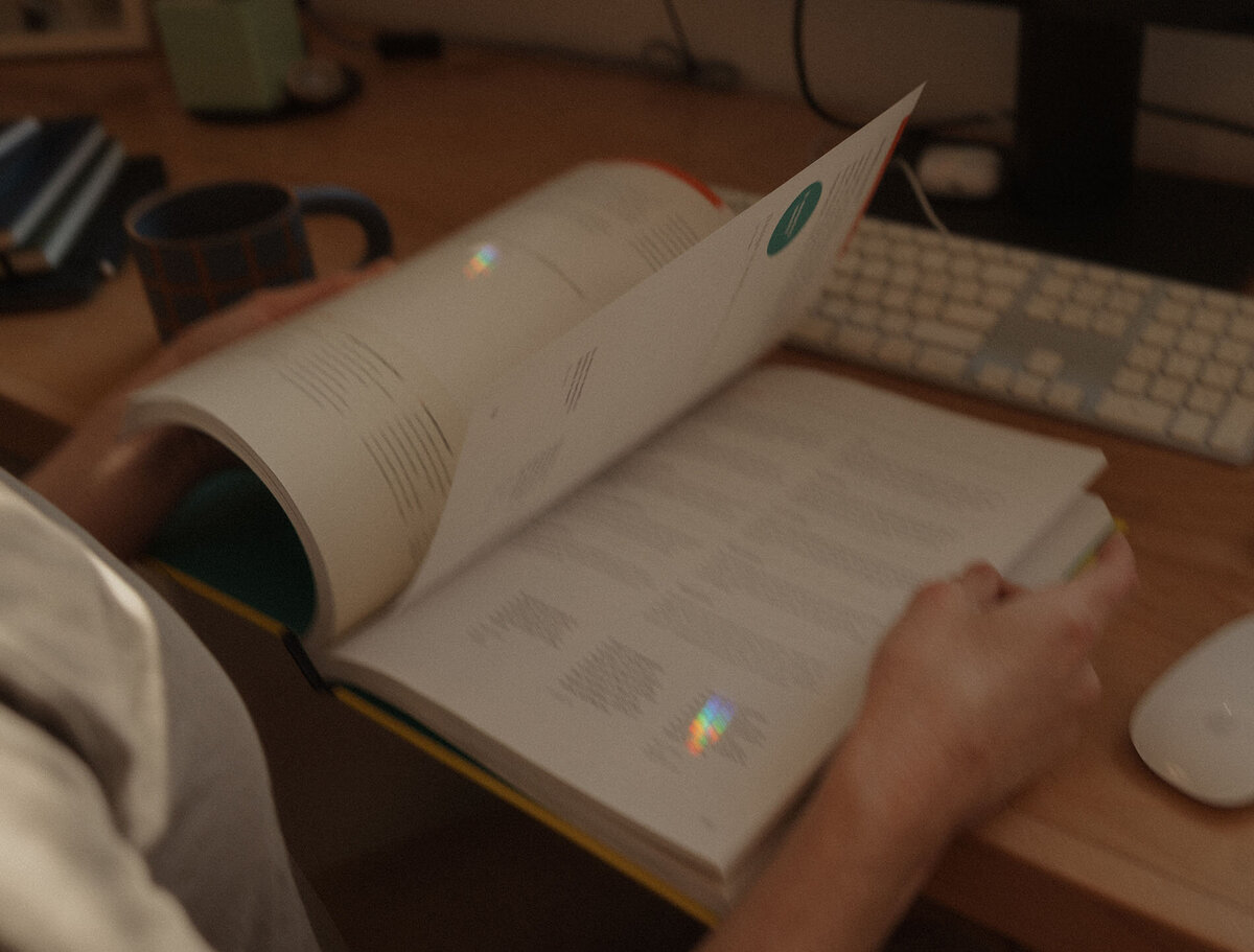 graphic designer business owner flips through a brand book at her desk in Bend Oregon