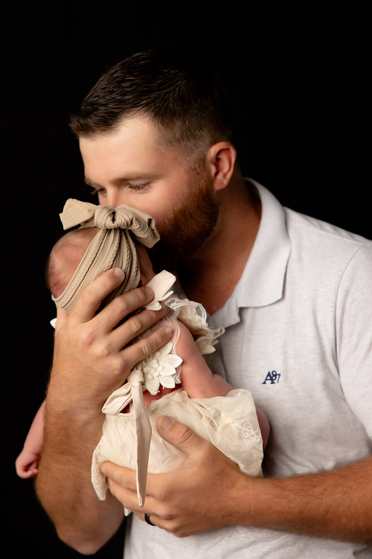 dad kissing newborn on forehead