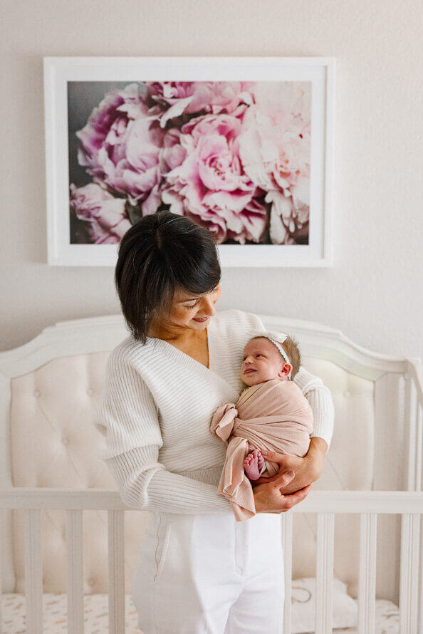 Mom hold her newborn baby in the nursery.