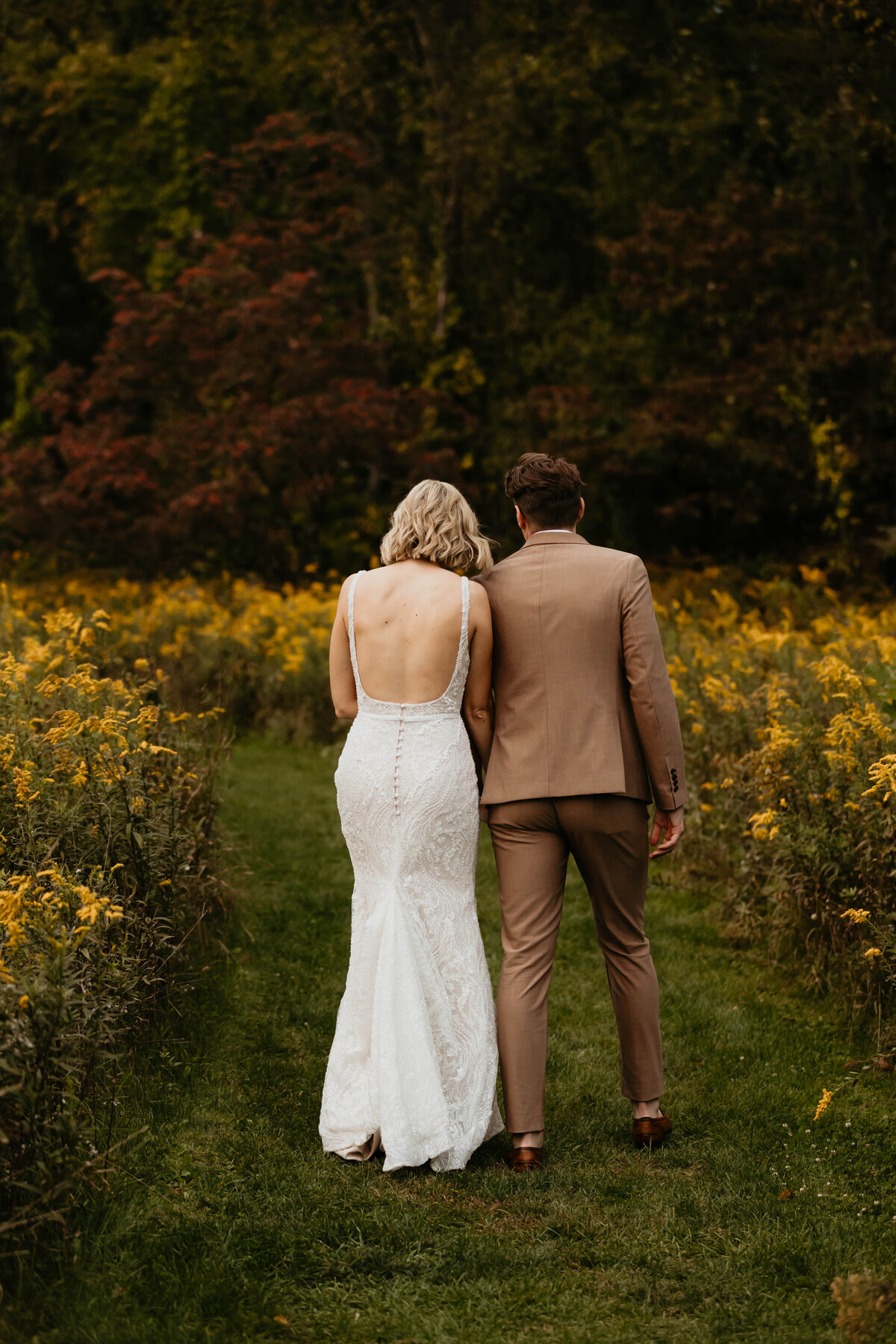 Bride and Groom walking in Wildflower Field