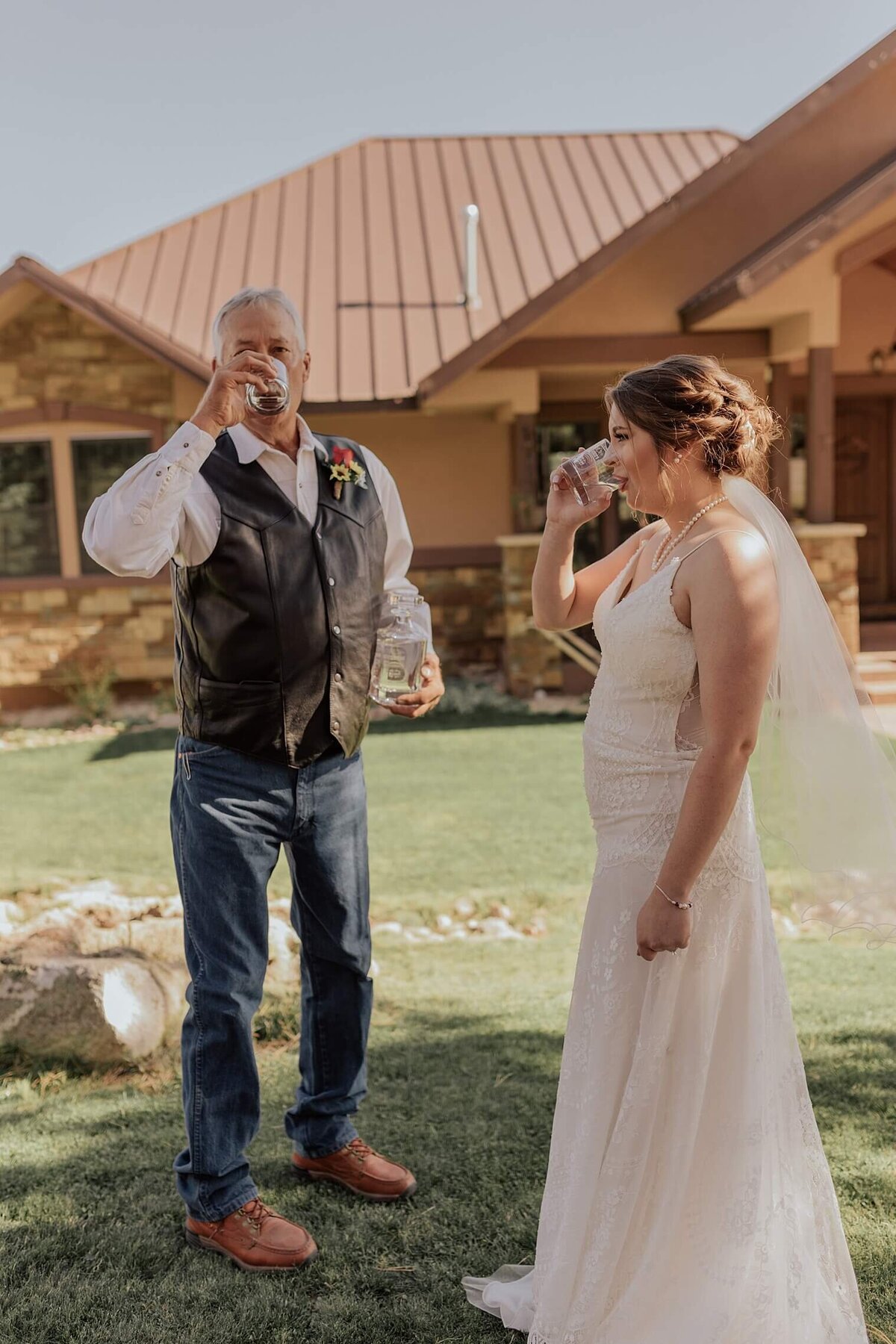 Bride and her father take a drink of whisky together