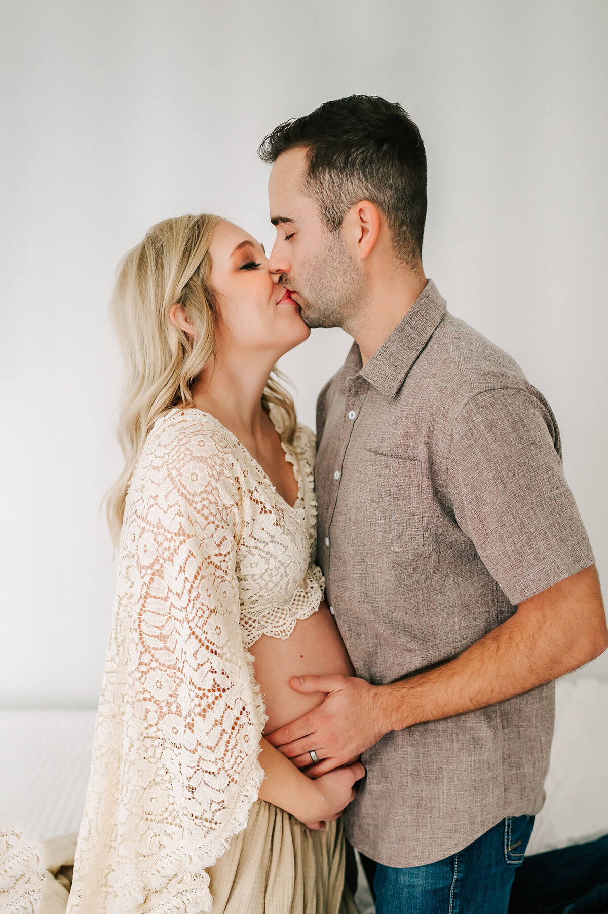 Springfield MO maternity photographer Jessica Kennedy of The XO Photography captures pregnant couple kissing while holding baby bump