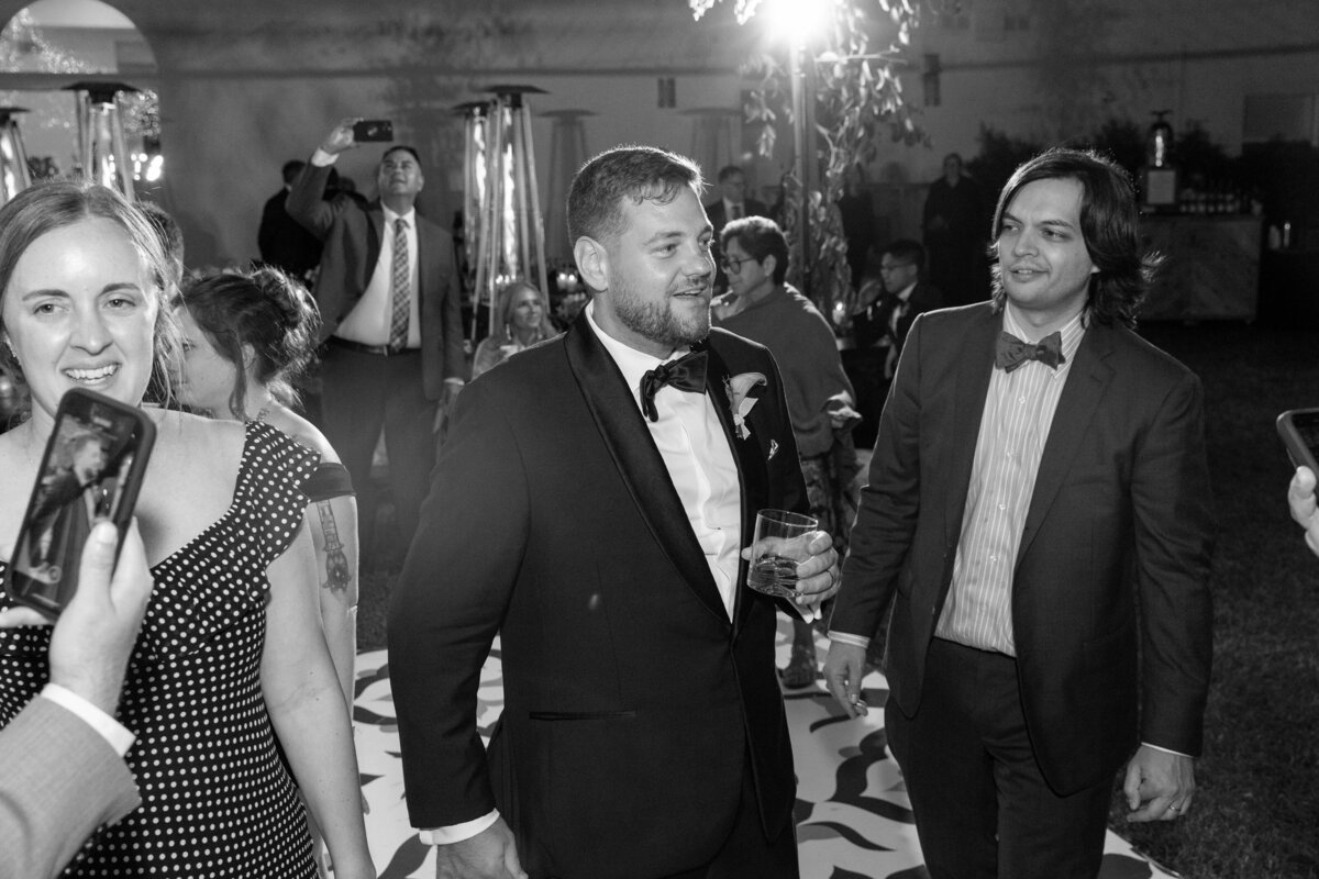 groom on the dance floor wearing a black tuxedo