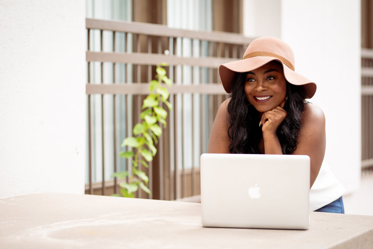 Woman in hat with computer