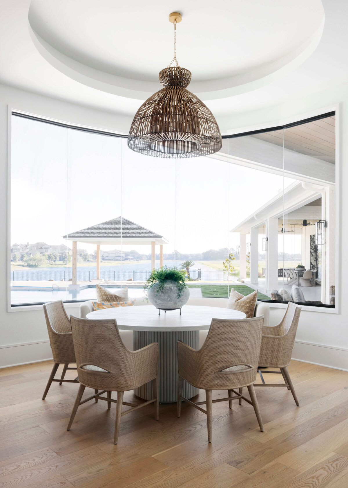 oyster creek studios hughes wicker lamp around white table and wicker chairs in dining room
