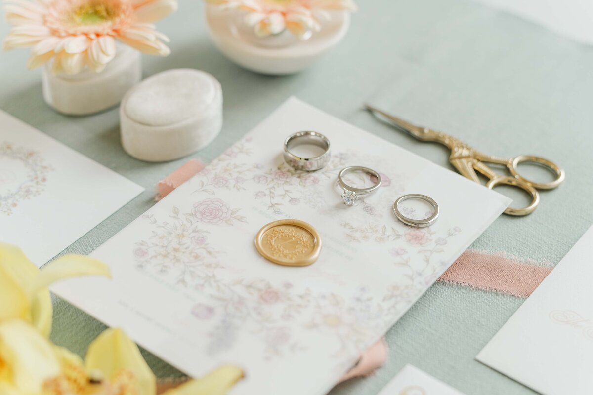 set of wedding invitations with thhe rings on top