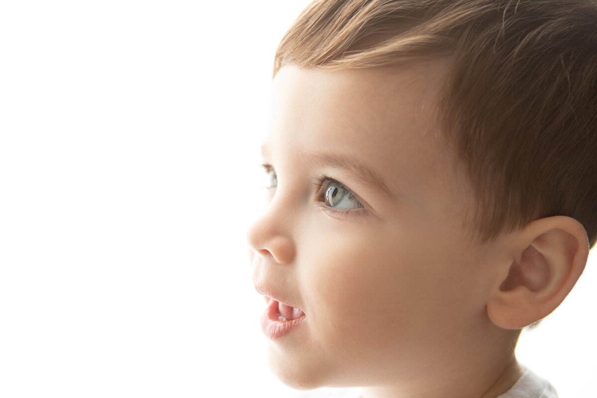 Backlit high contrast studio portrait of a young boy'