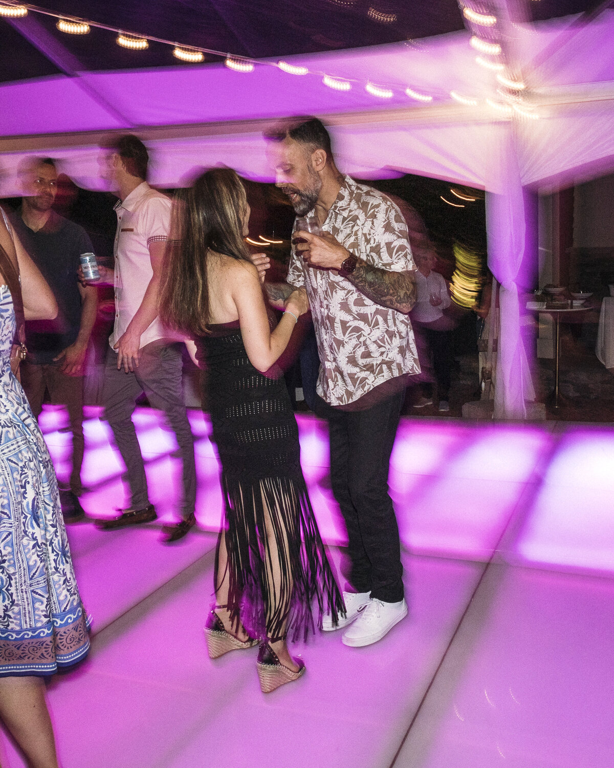Photo of couple dancing on neon pink dance floor in private backyard party by Mira Park Photography NY based wedding photographer