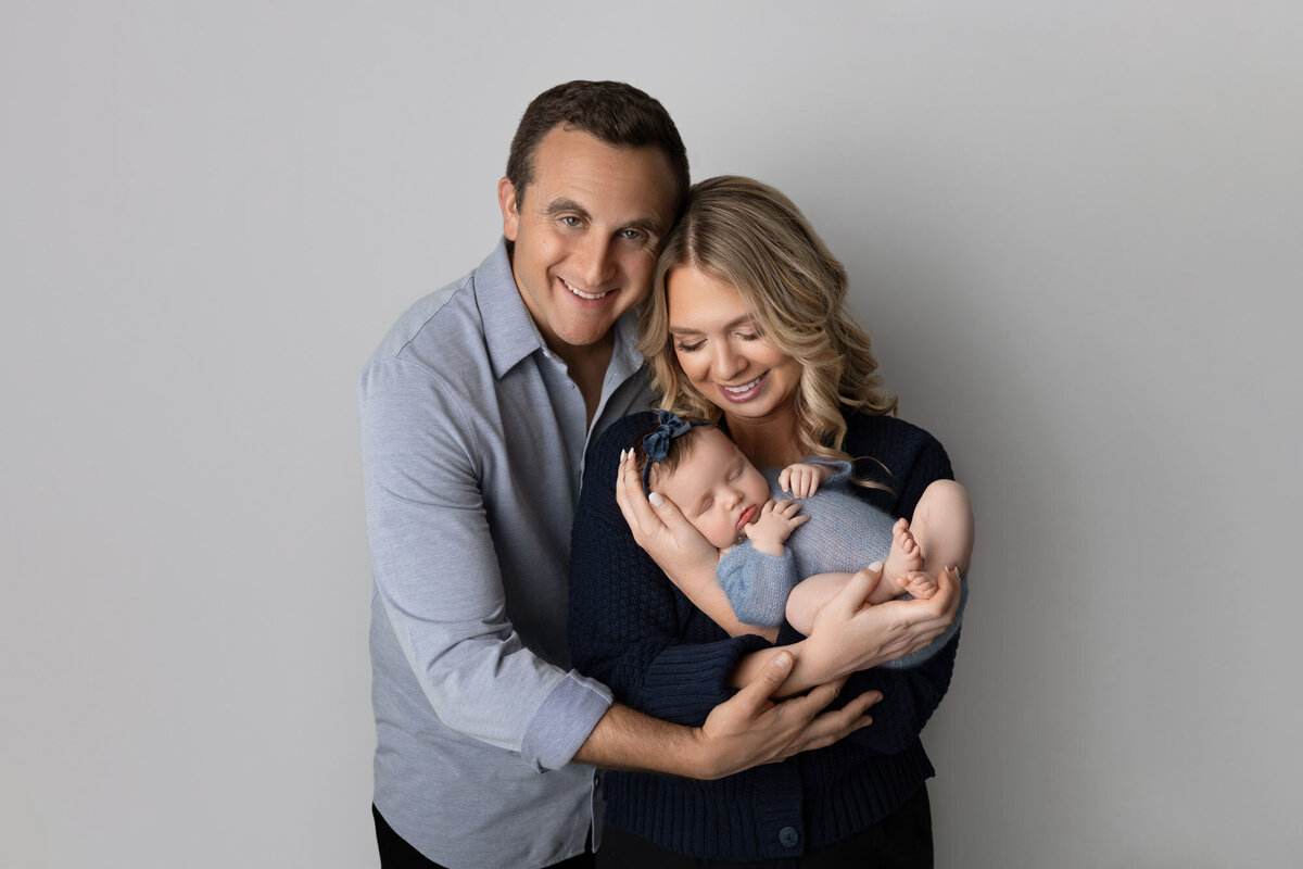 Happy parents holding newborn baby family portrait Westlake photographer