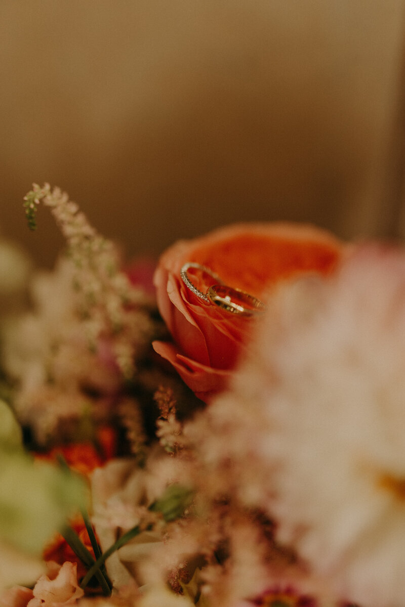 Zoom sur des alliances présentés sur la rose d'un bouquet de fleur. Photo capturée par Laura Termeau photographie.