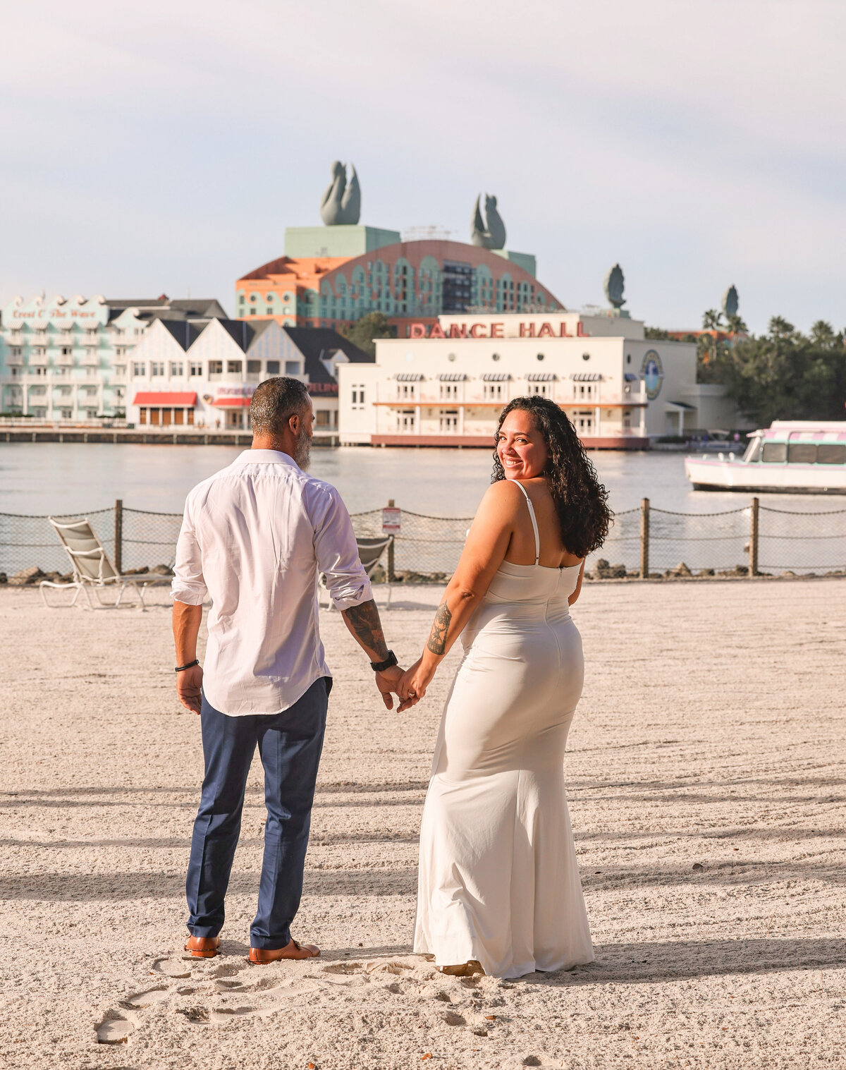 bride and groom holding hands walking together at Disney Boardwalk by Orlando Florida elopement photographer Amanda Richardson Photography