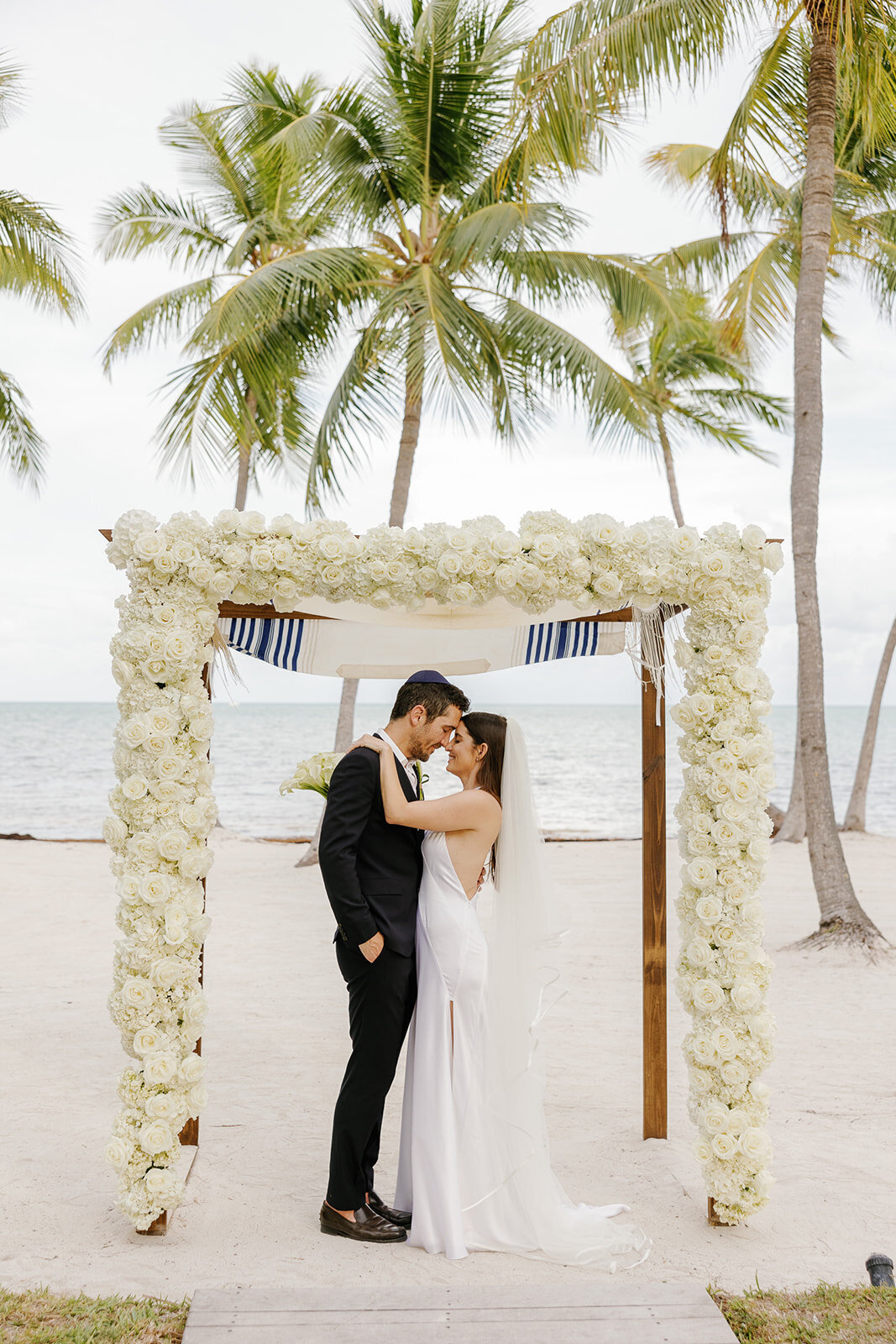 A romantic first kiss as husband and wife at Casitas at Cheeca. Destination wedding photography by Claudia Amalia.