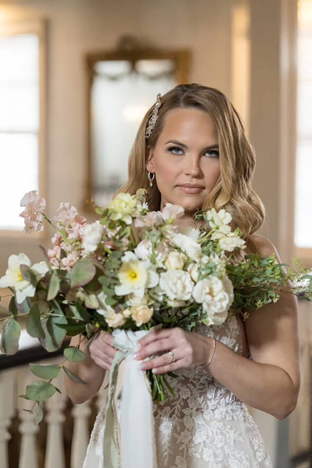 Beautiful bride in a unique wedding dress holding a floral bouquet, showcasing radiant skin and flawless makeup by Skinlux Beauty Bar.