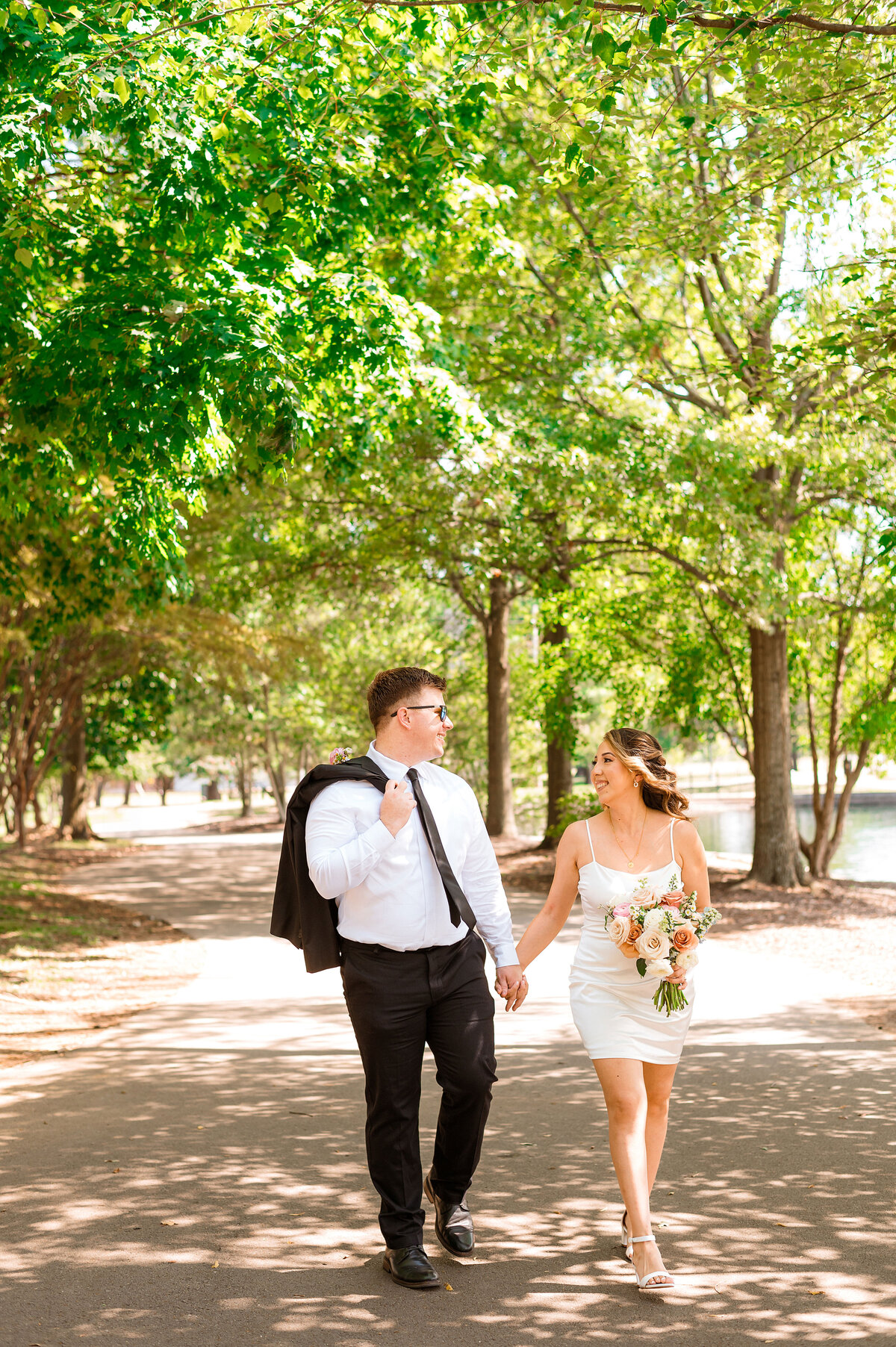 Newly eloped couples walking hand in hand in park