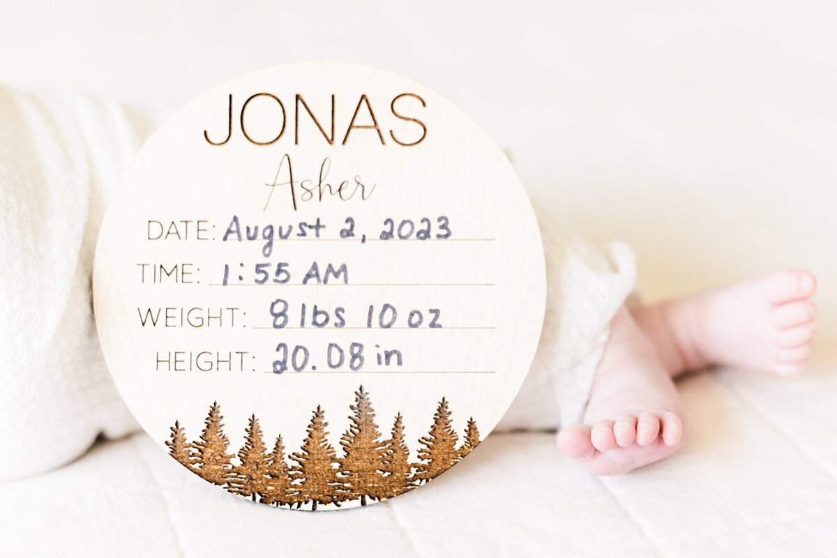 Birth stats sign and baby toes during a lifestyle newborn photo session