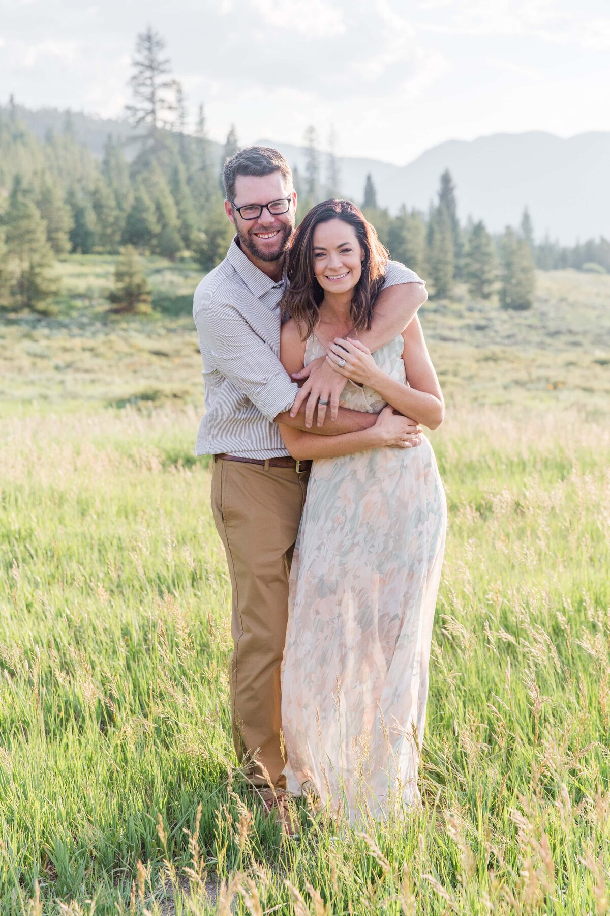 husband wraps arms around wife colorado mountains
