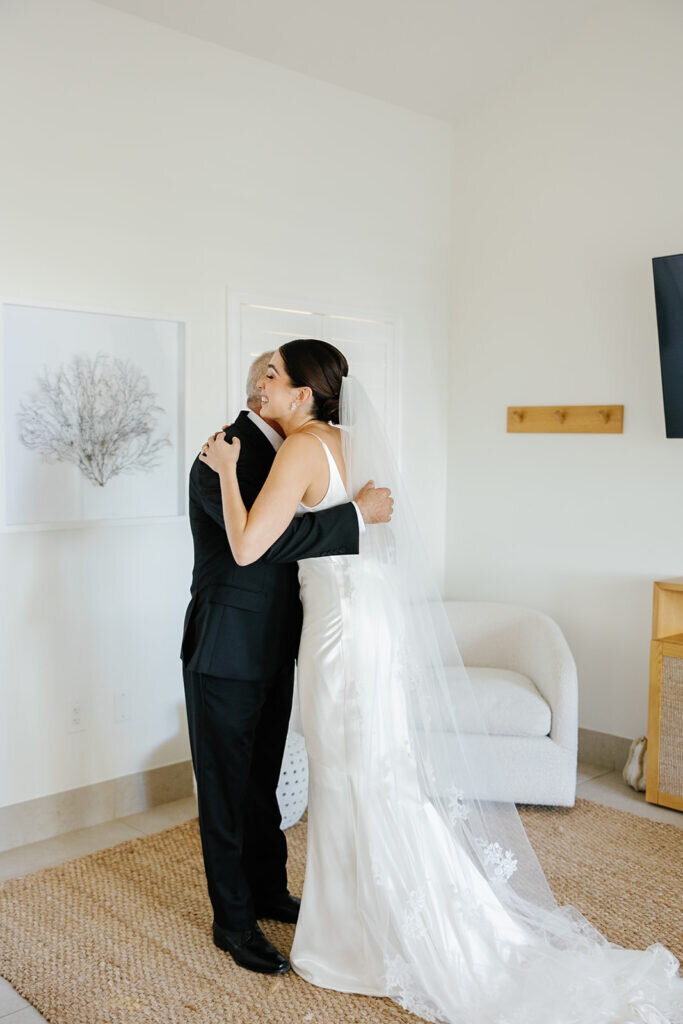 A joyful embrace between the bride and her father, filled with emotion before walking down the aisle. Destination wedding photography by Claudia Amalia Photography in the Florida Keys.