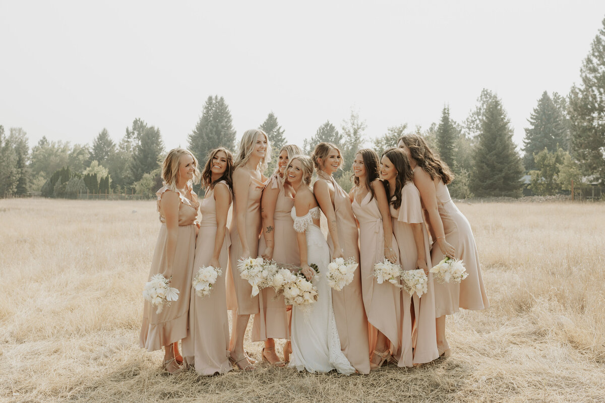 Bridesmaids laughing in field