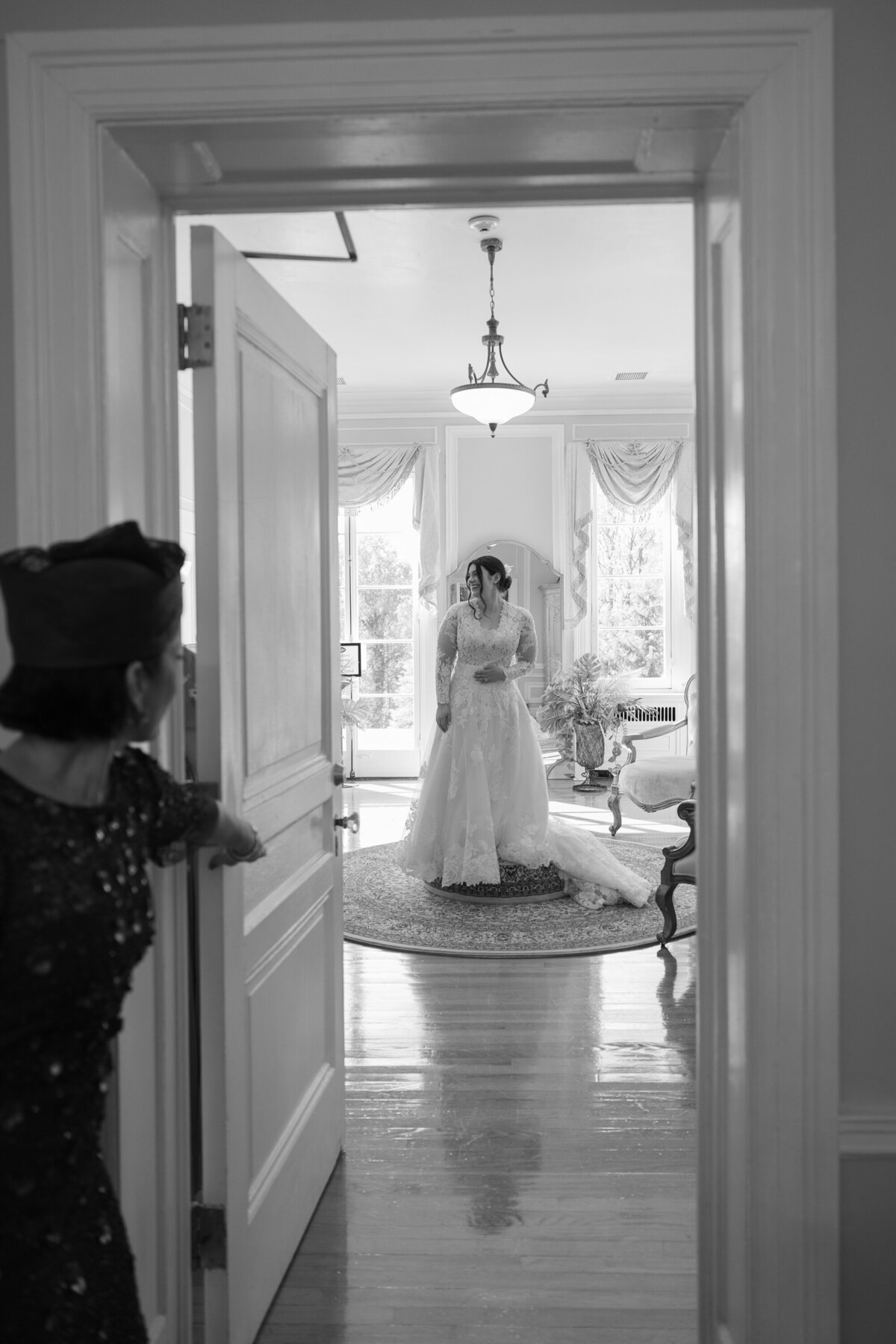 mother of the bride looks in at her daughter in the bridal suite
