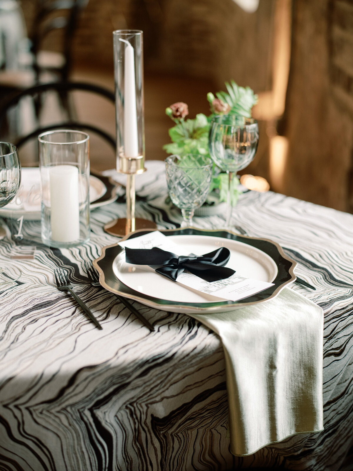 A stylish modern table setup featuring abstract elements and a chic black ribbon on the plate, creating a visually appealing and artistic place setting.