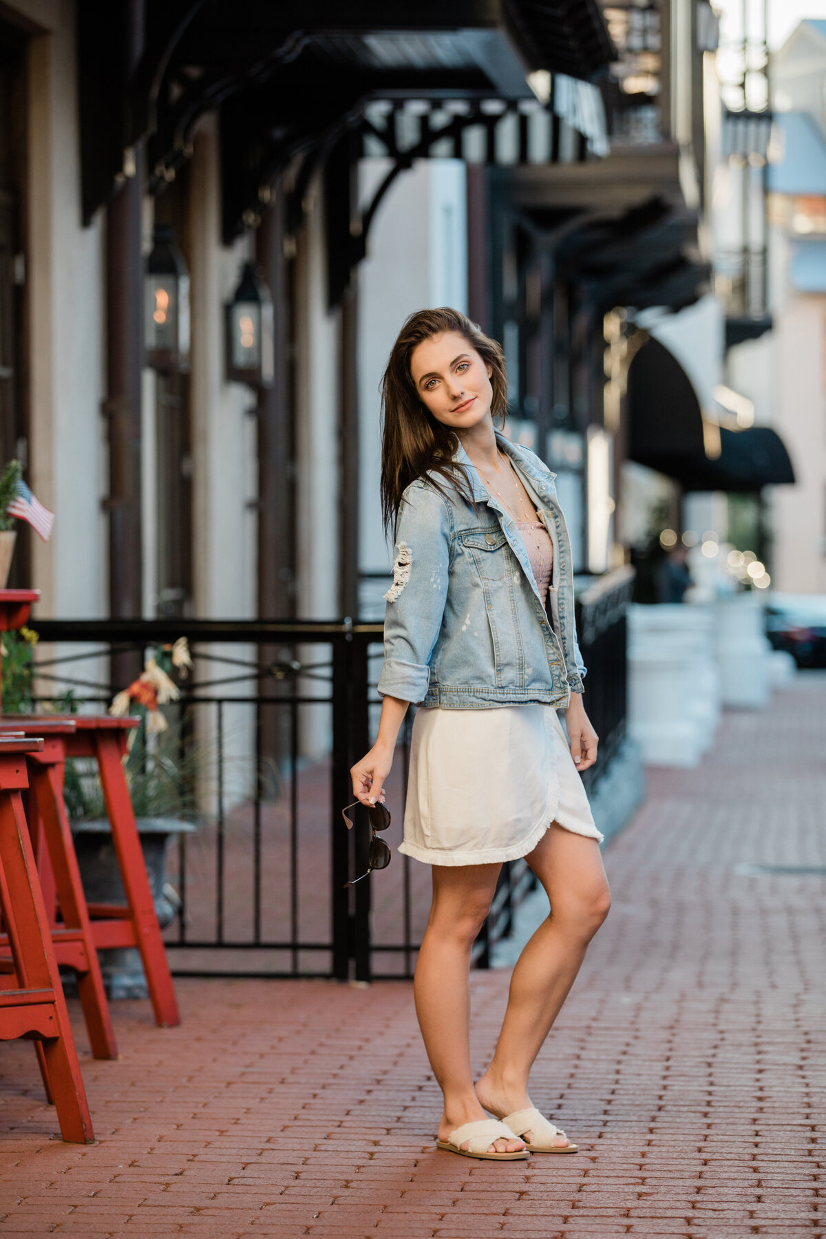 A girl standing on a brick sidewalk