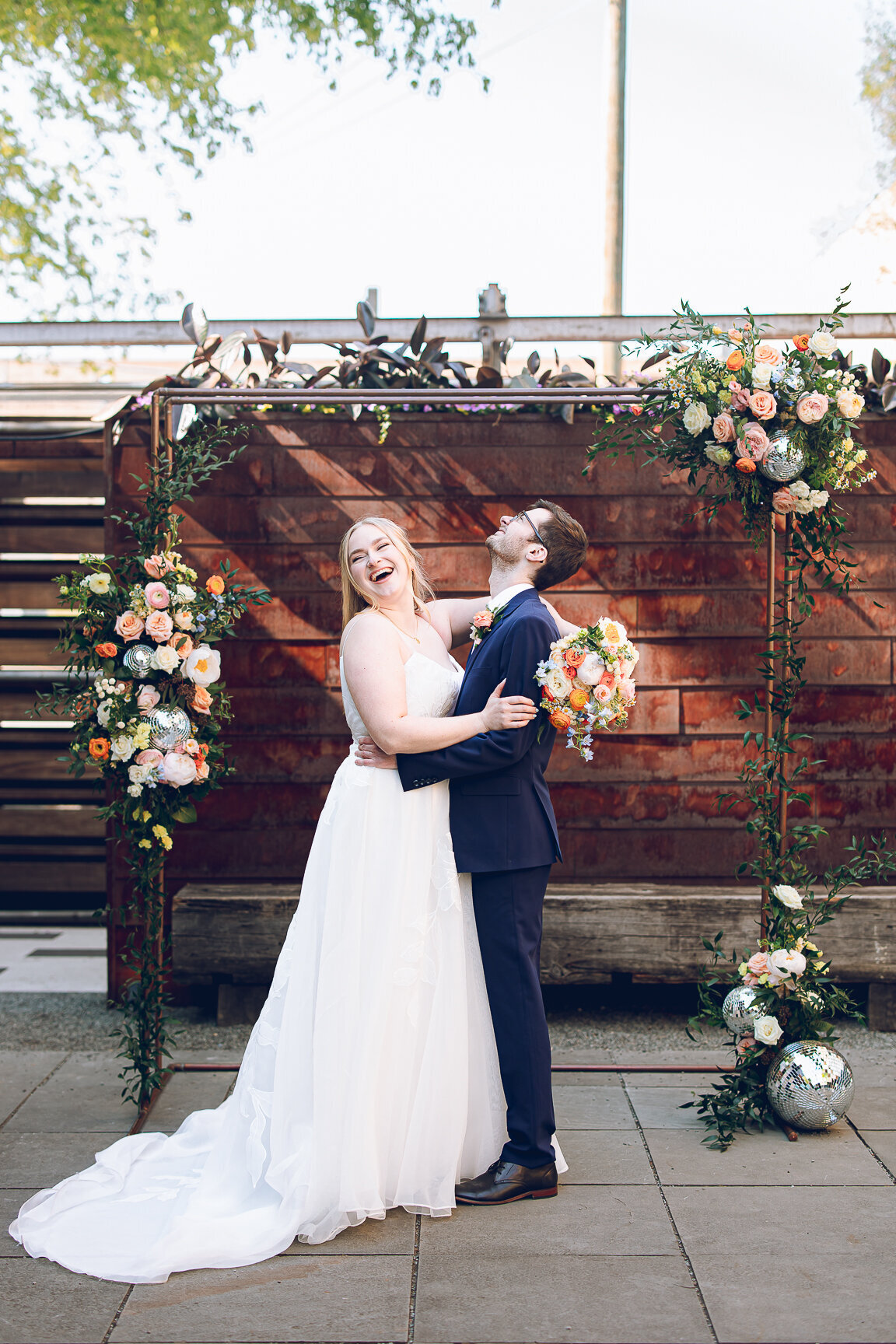A couple pose under their floral alter at The Joinery Chicago