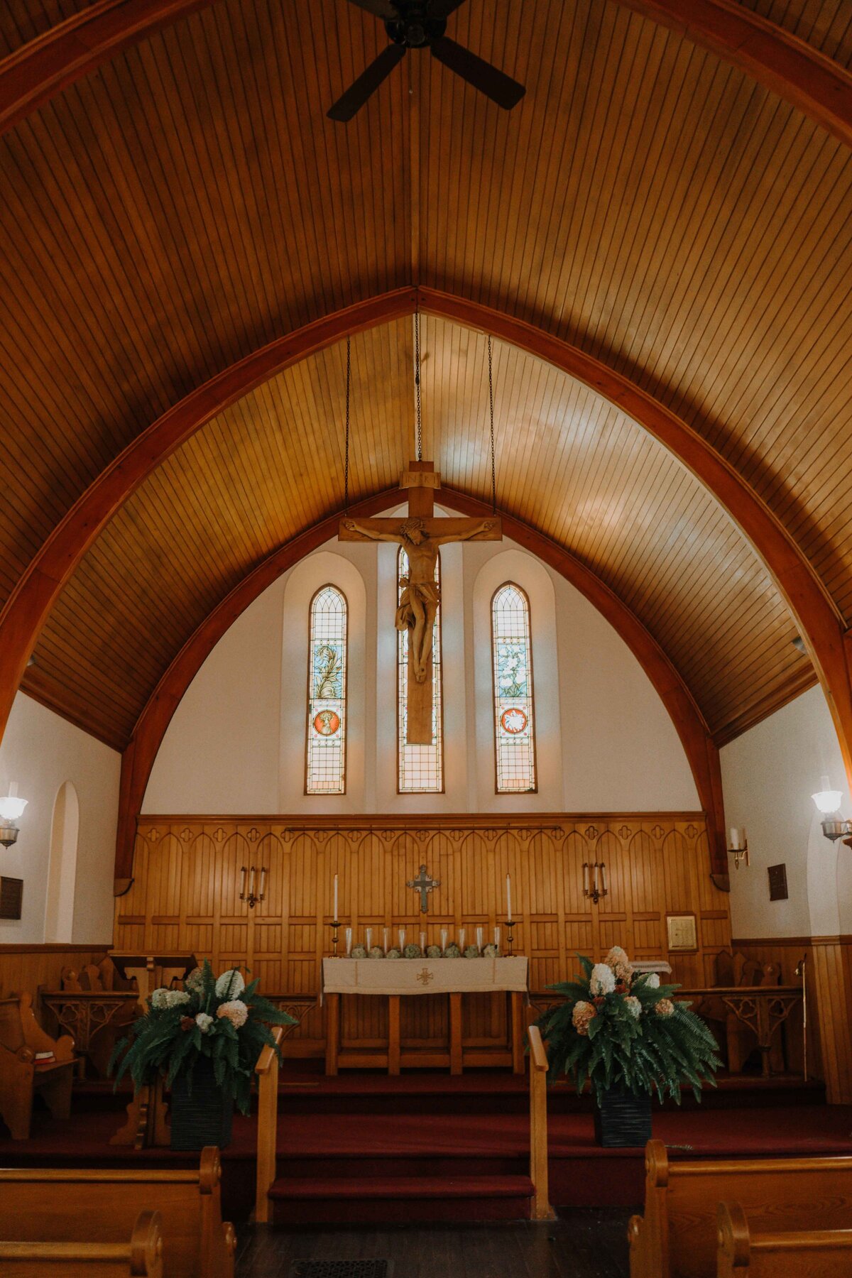 inside of a church thats all wood with stained glass