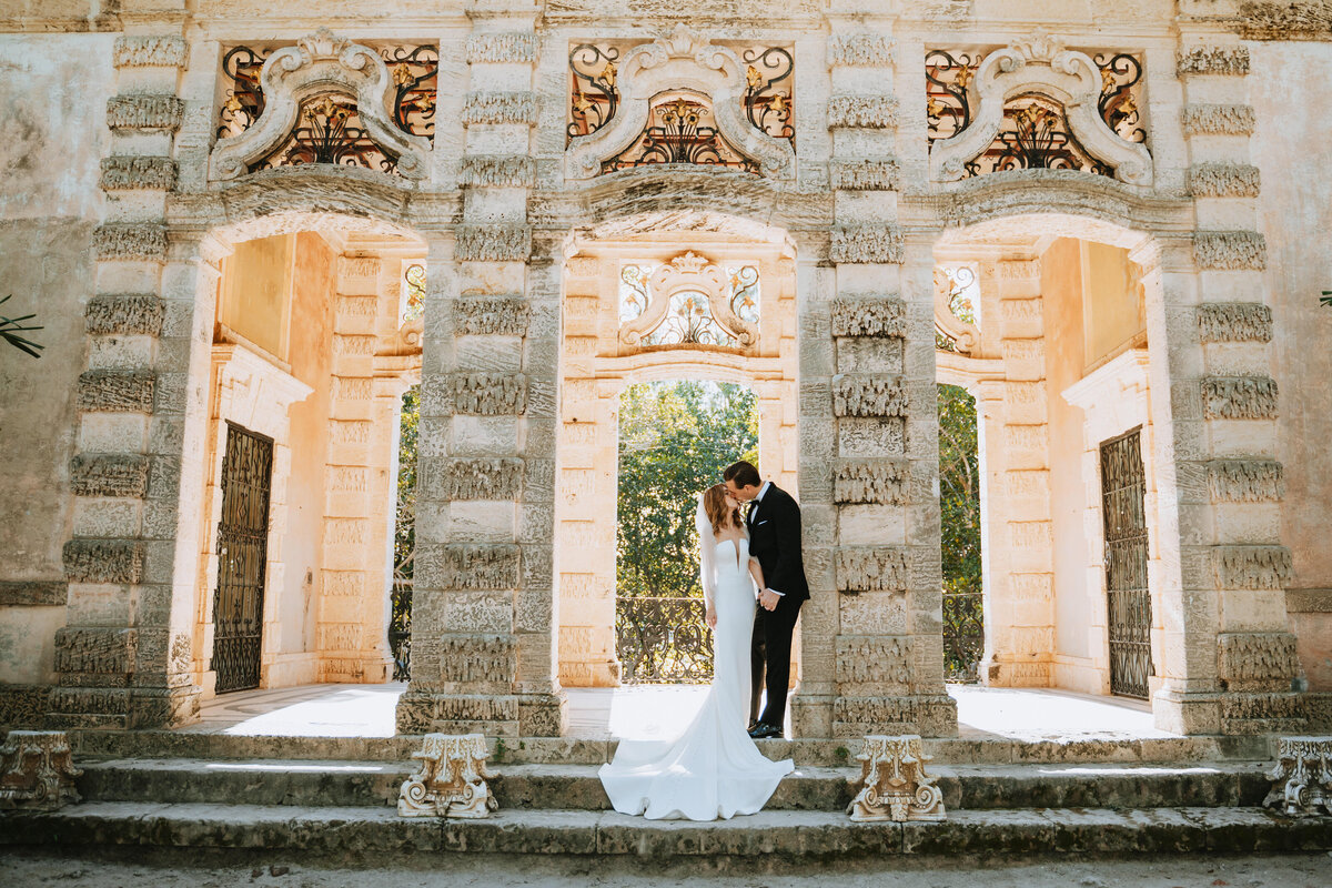 bride and groom kissing on steps at vizcaya museum and gardens