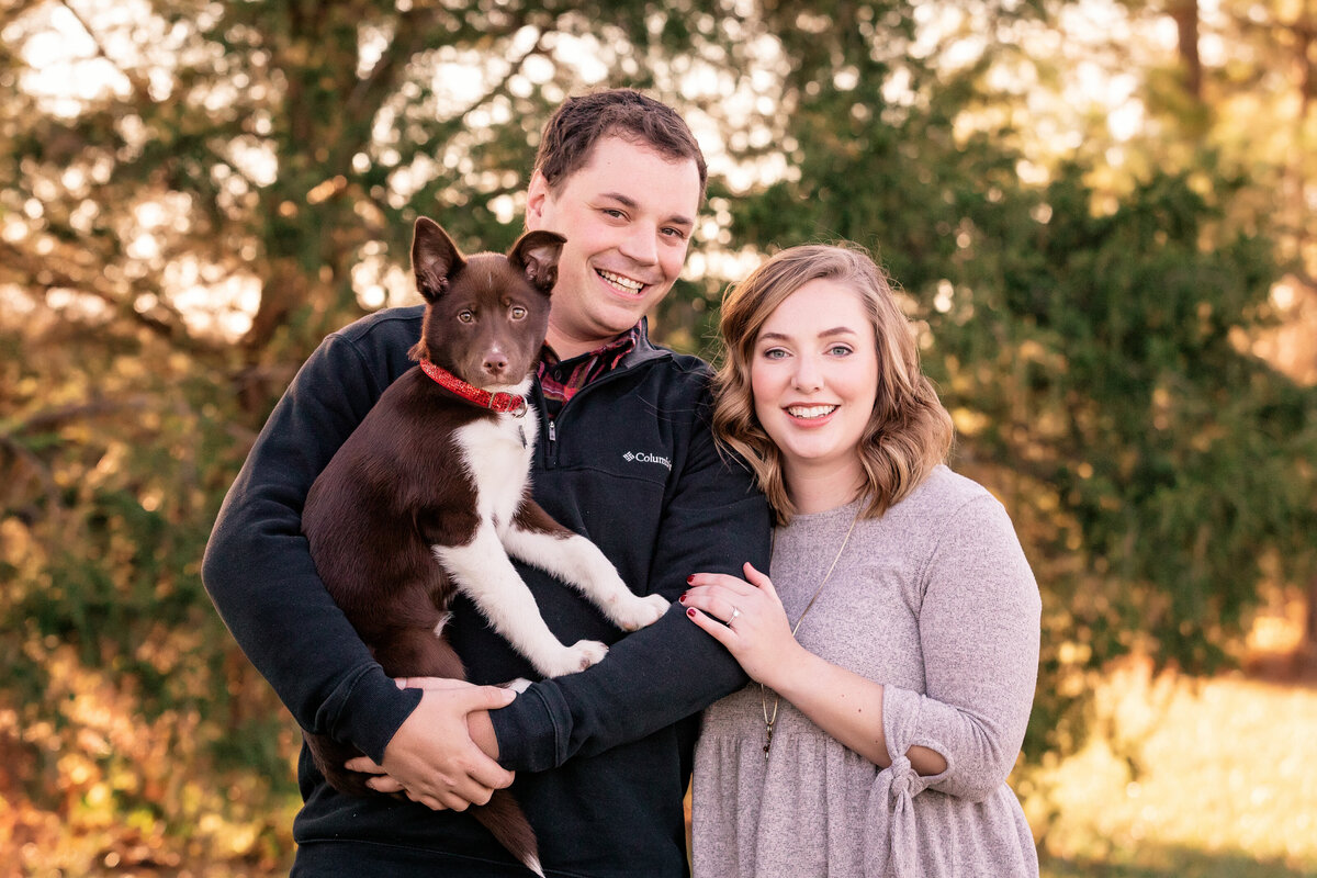couple with dog looking at camera