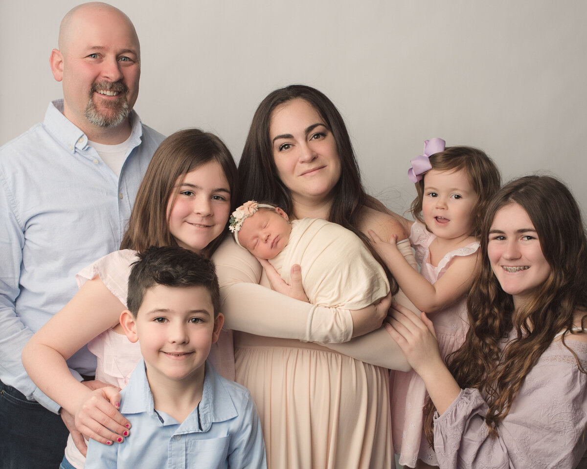 Fairfield County CT studio, New Haven CT Studio, Newborn girl family portrait with mom, dad, three big sisters and big brother all dressed in neutral colors  on neutral backdrop
