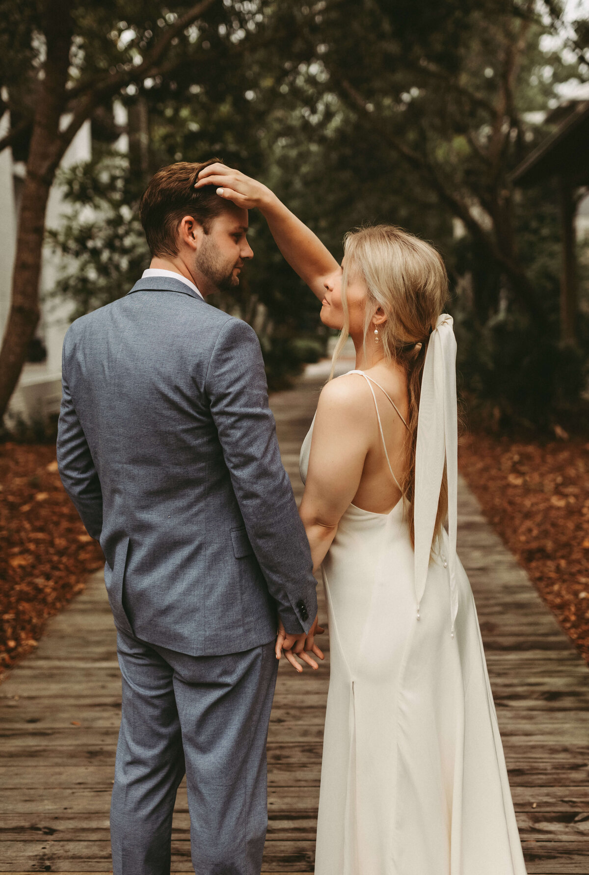 bride moves grooms hair gently after intimate elopement in south walton florida