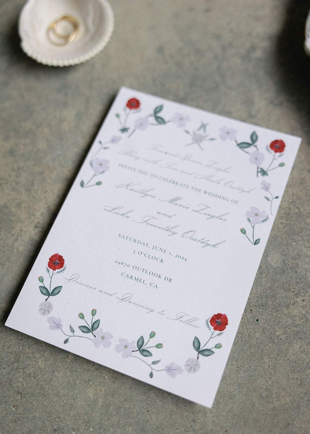 Floral wedding invitation on a concrete surface